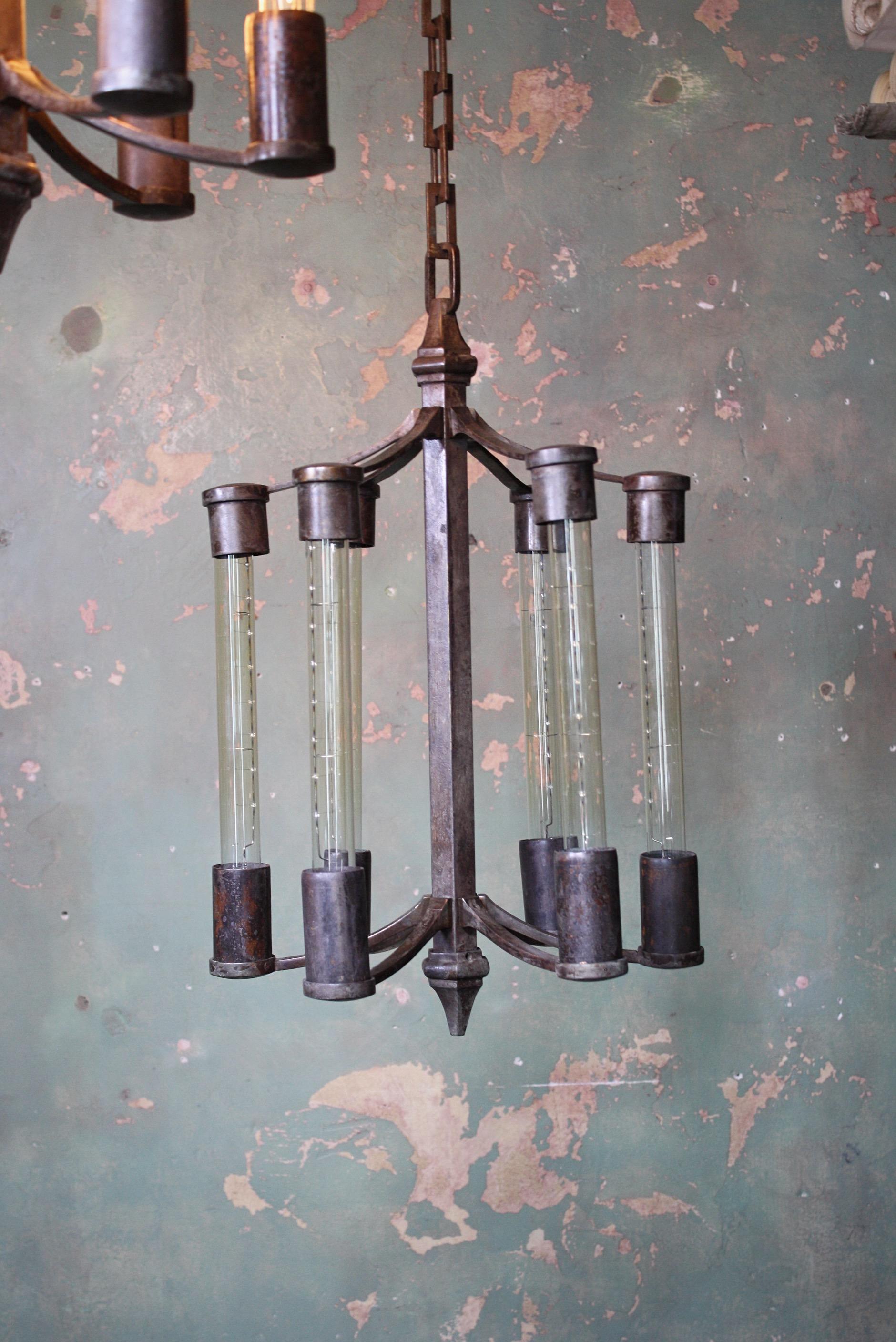 A striking trio (two sold) of unusual cast bronze pendants, the central column has six arms that contain the elongated filament bulbs with collars at either end. 

The pendants have new t30 dimmable Edison bulbs, all metal sections have a warm and