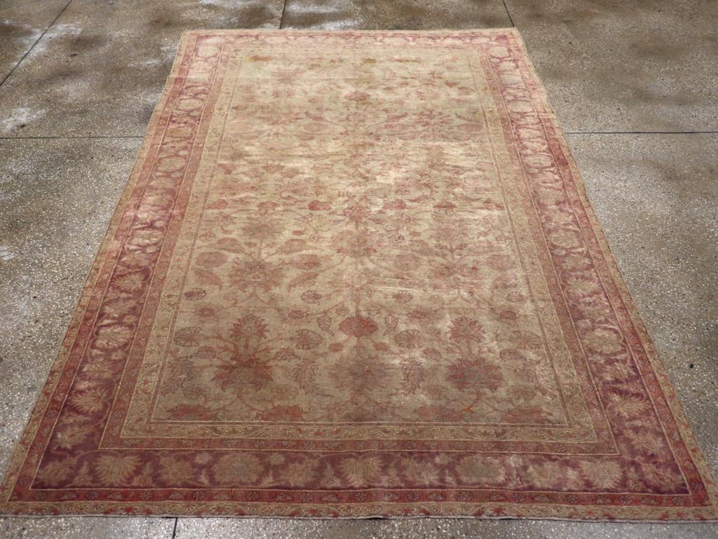 An antique Turkish Oushak accent rug. Definitely in the 1920’s Mahal style, with a central palmette axis and rounded arabesques and more palmettes and curving leaves, this Oushak has softer colors and higher pile than its Persian contemporaries. The