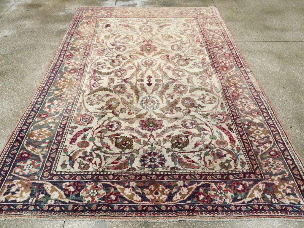 An antique Turkish Oushak accent rug. The old ivory field of this attractive west Turkish carpet has a bilaterally symmetric layout of forked acanthus leaves and vigorous arabesques anchored by or ending in classical Persian –style palmettes. A vine