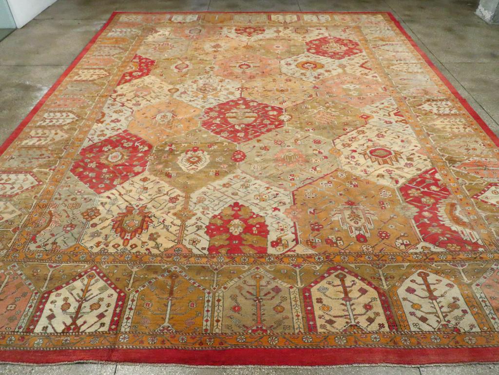 Ein großer antiker türkischer Oushak-Teppich. Dieser attraktive westanatolische Werkstattteppich verbindet kunstvoll zwei Designtraditionen. Das Feldmuster aus sechseckigen Kacheln in den Farben Creme, Goldrute, Stroh, Rost, Dunkelbraun und