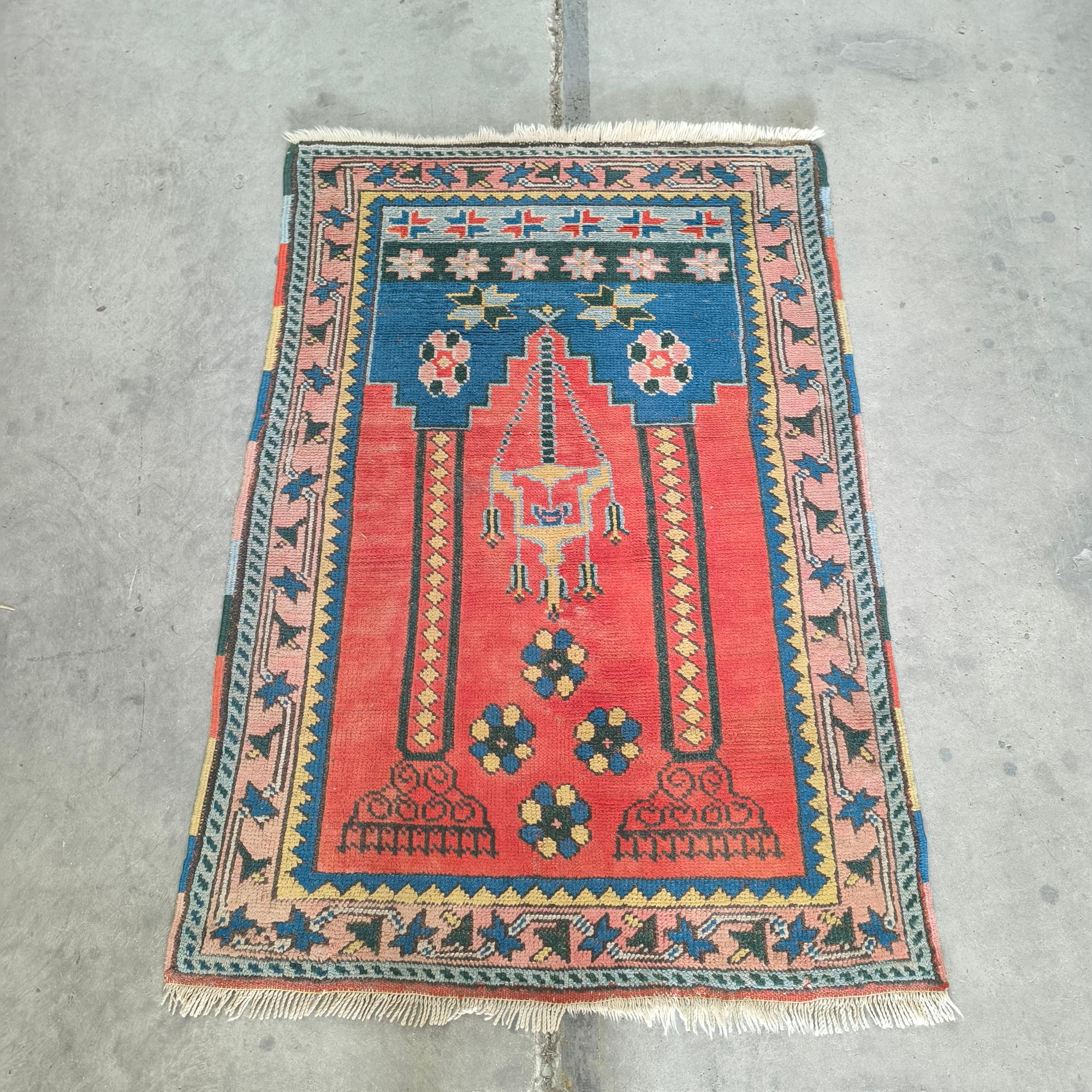 Tappeto da preghiera turco tessuto a mano dell'inizio del XX secolo, originario della regione dell'Anatolia. Realizzato in lana su base di lana, il tappeto presenta il disegno del mihrab centrale, tradizionalmente utilizzato per indicare la