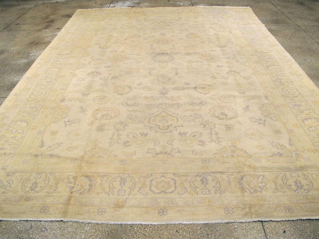 Tapis ancien turc de type Oushak, de la taille d'une pièce. Les Oushaks légers, comme ici avec une tonalité d'huître, ne semblent jamais se démoder. Le champ présente un motif de palmettes déconnectées et la bordure de même couleur montre des