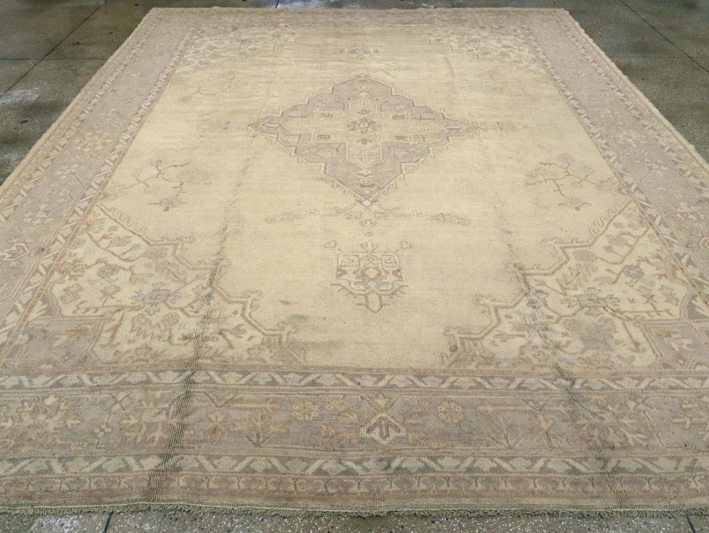 Tapis ancien turc de type Oushak, de la taille d'une pièce. Ce Oushak d'atelier de Turquie occidentale aux couleurs douces est de style Heriz avec un champ semi-ouvert de couleur pêche centré par un médaillon de diamants en escalier et placé dans