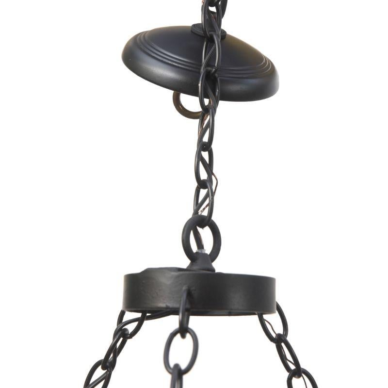Rustic wrought iron chandelier with twelve lights. Six long curved arms, and six short arms. The main body of the chandelier is suspended by three chains from an iron circle. Turned center stem. Completely restored and rewired. Early 20th