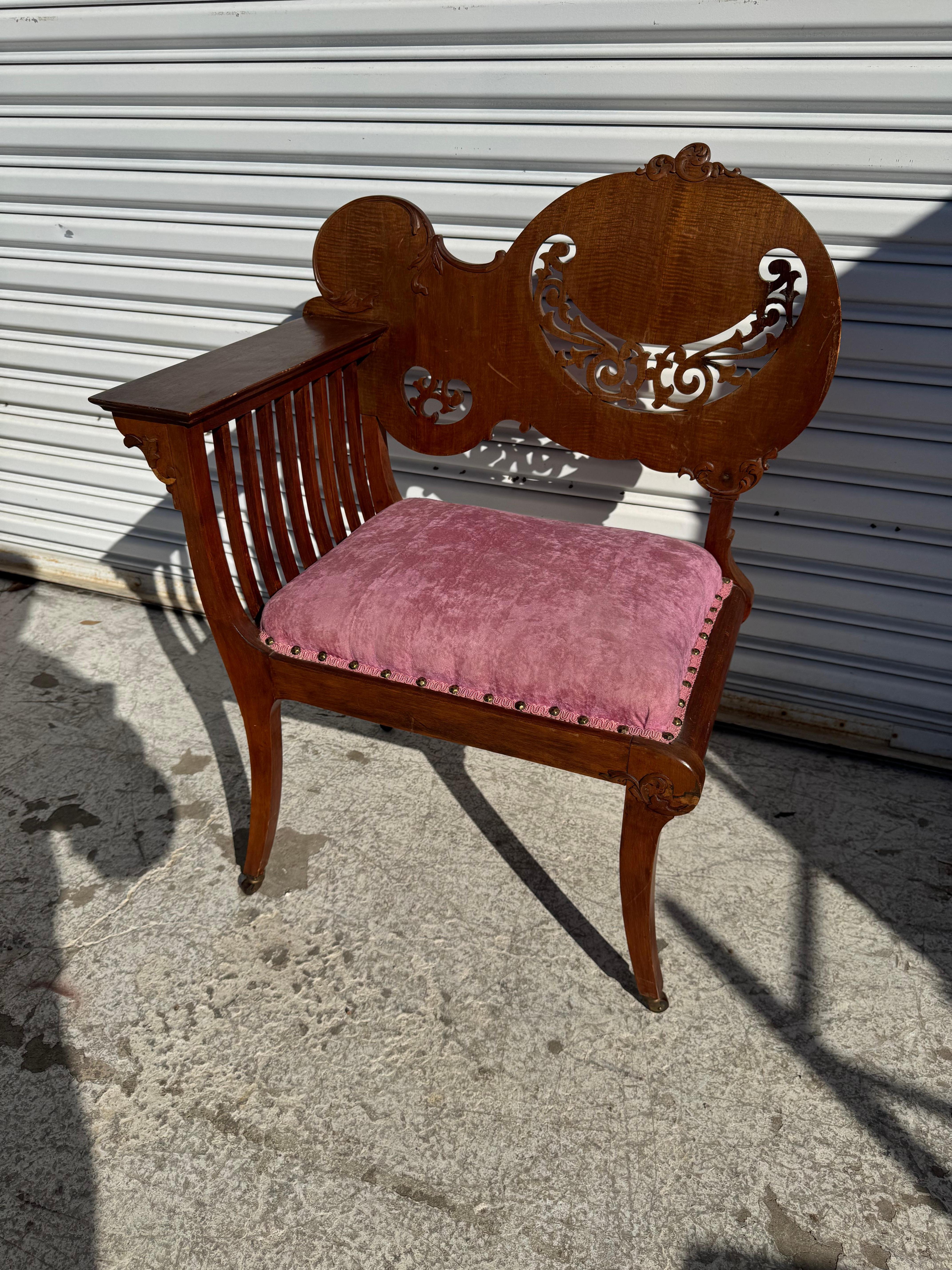 Il s'agit d'une chaise d'angle très sculptée.
Il est doté d'un accoudoir à lattes et d'une assise rembourrée.
Les pieds cabriole reposent sur des roulettes en laiton.