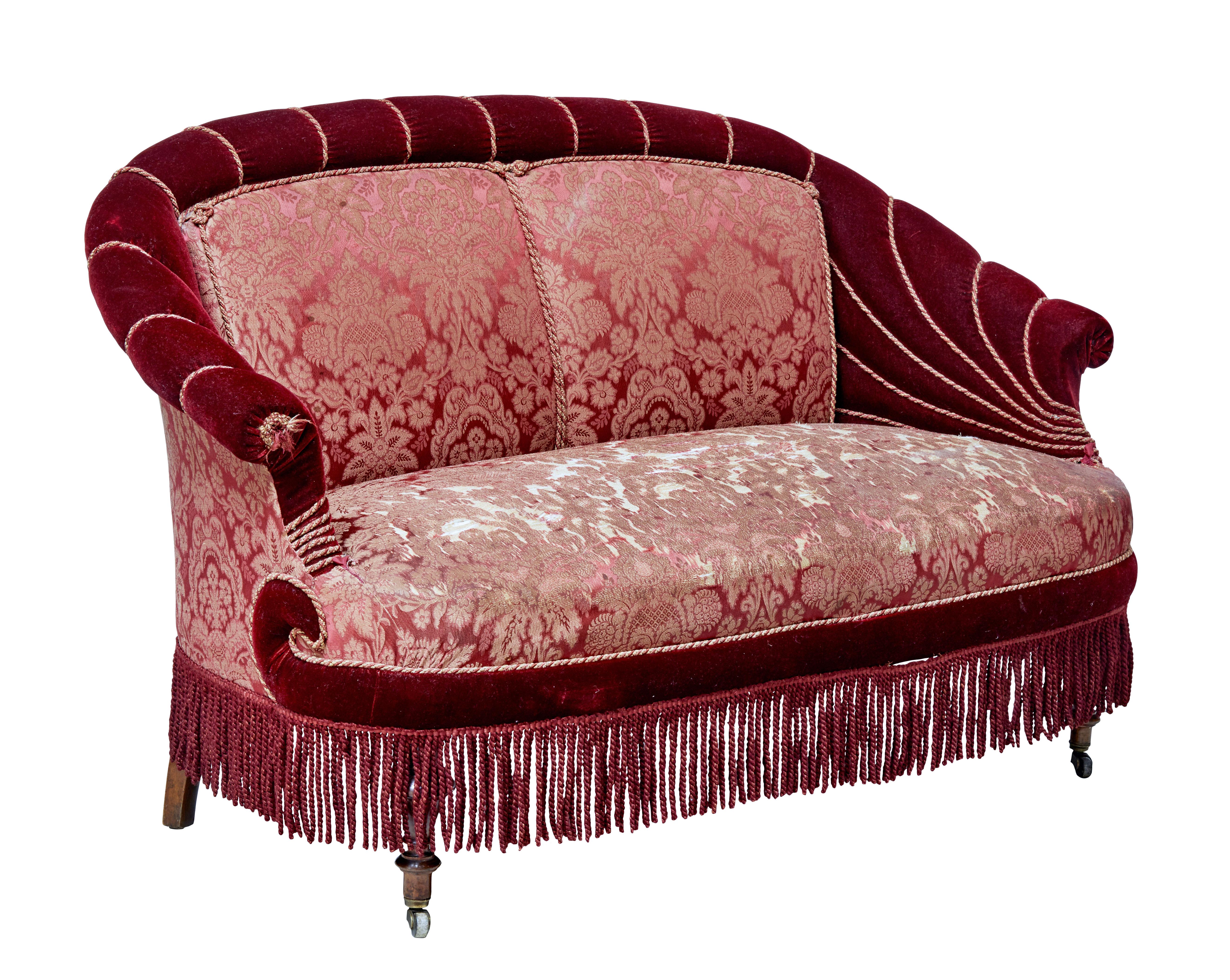 Rare five piece salon suite, comprising on a sofa, two arms and two nursing chairs.

Red velvet with piping and tassles. Floral pattern provides a fitting contrast to the bold red fabric.

Standing on front mounted castors.

Wear and holes to