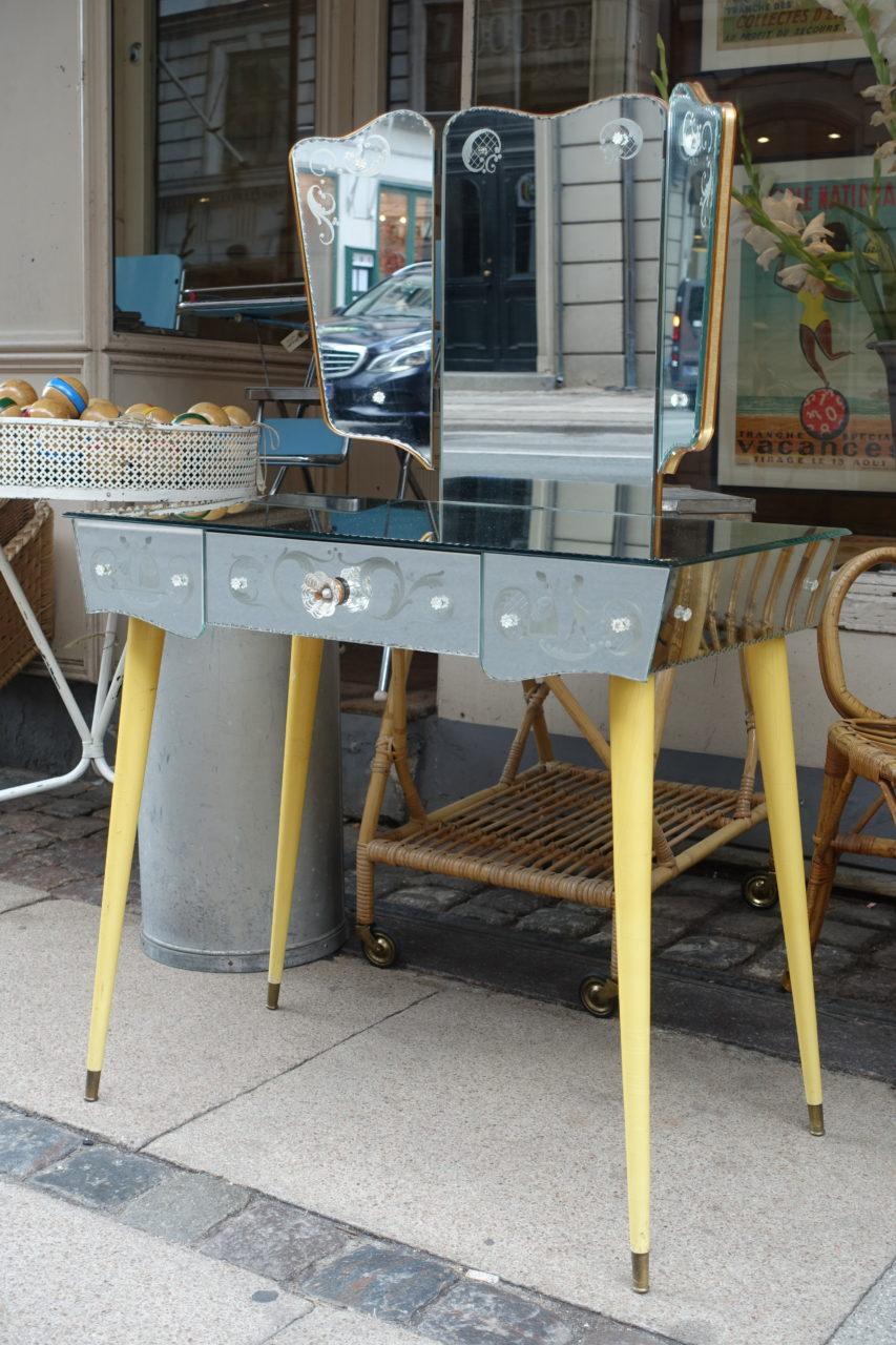 Lovely Venetian dressing / vanity table, from circa 1920-1940. Charming slanted elegant legs in a sunny yellow shade. Elaborate mirrored glass, with super etching work and decorations. A front drawer with a glass handle, and three panelled mirrors.