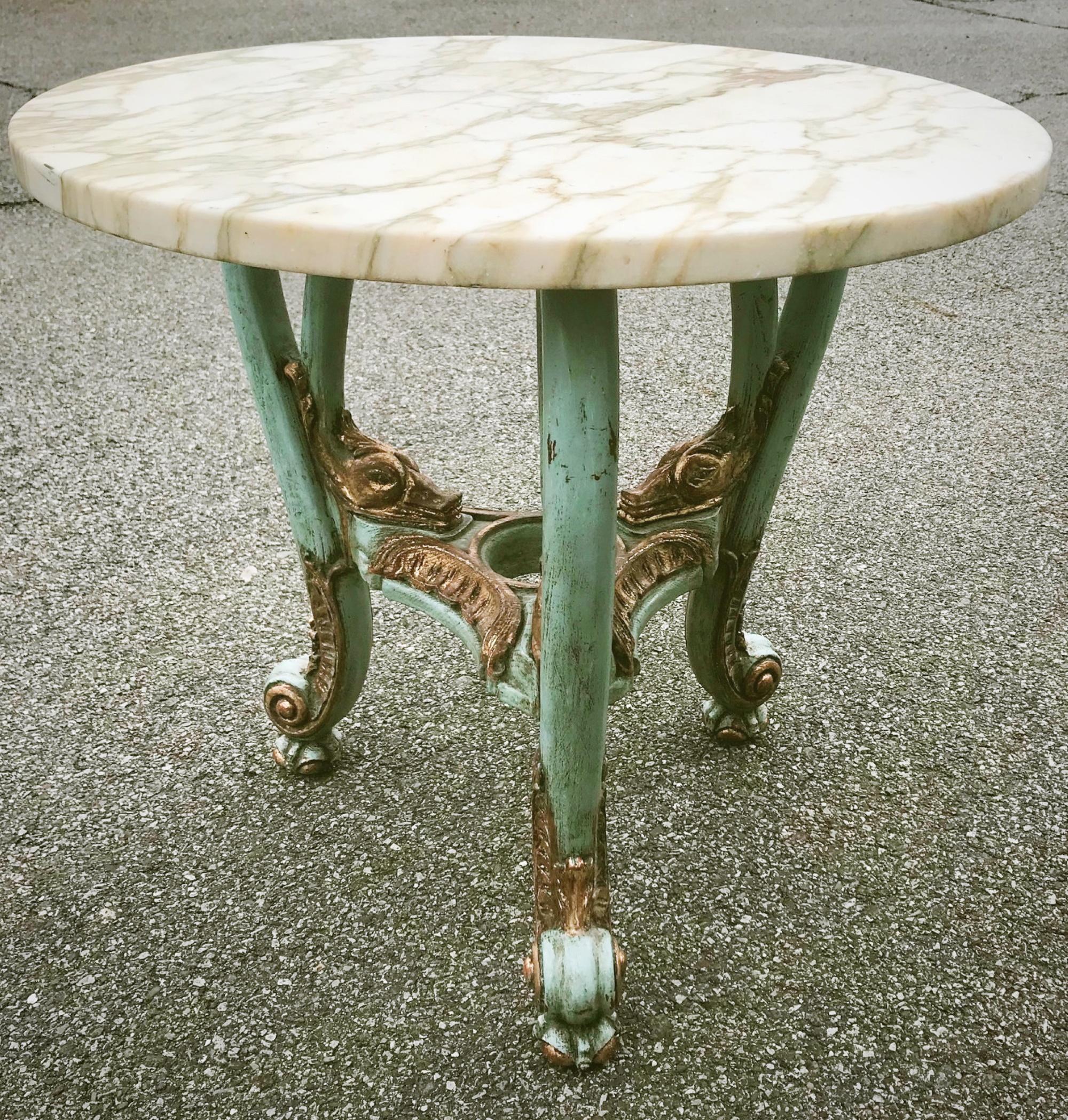 This round table is constructed in carved and polychrome wood. It has a marble top in circular shape. Beautiful carvings of rocaille, swan heads and claw feet are emphasized with gold gilding. The center under tier has a round opening, probably for