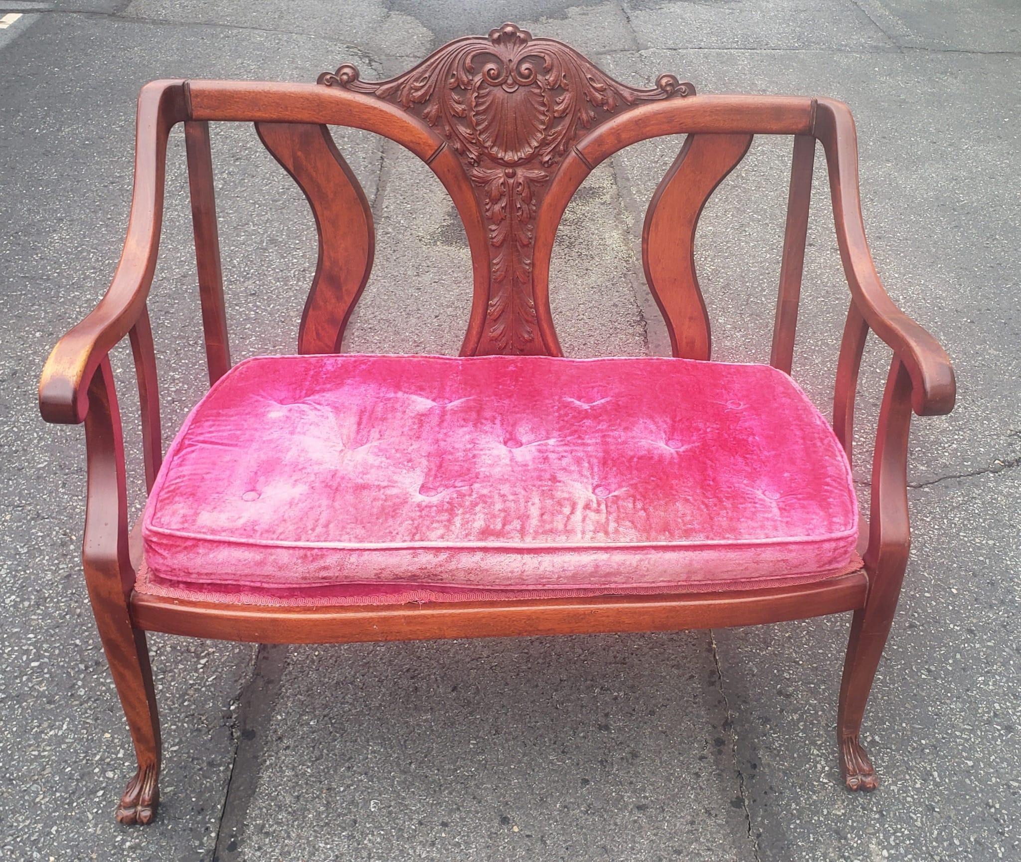 An Early 20th Century Victorian Style Carved Mahogany and Upholstered Settee with impressive center back carving.
Measures 41