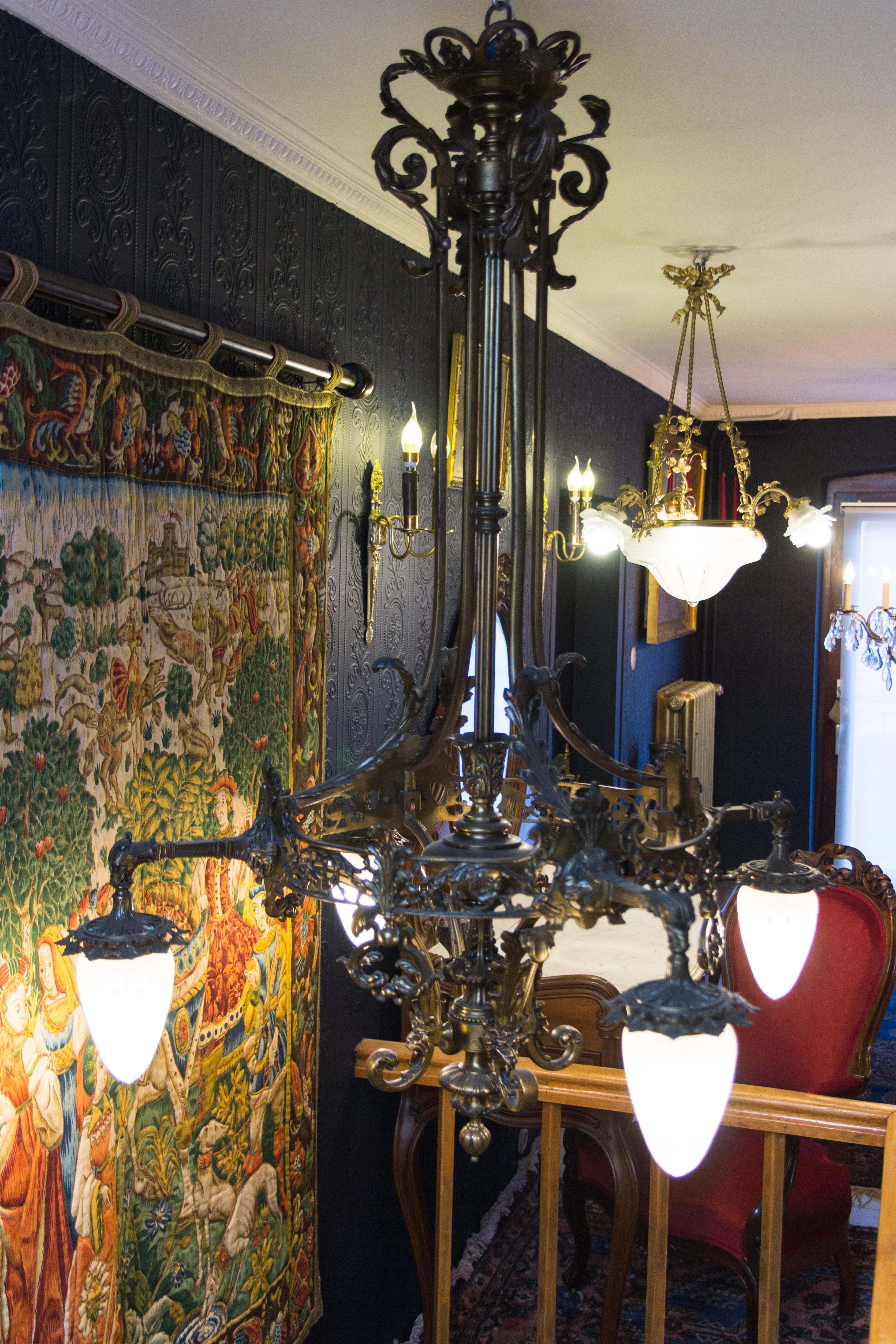 Dieser große und beeindruckende Kronleuchter mit vier Lichtern aus Bronze im viktorianischen Stil wurde in den 1920er Jahren in Belgien hergestellt. Reich verziert mit Blattwerkdekor und gehörnten Satyrköpfen. Die Köpfe von Fabelwesen halten vier