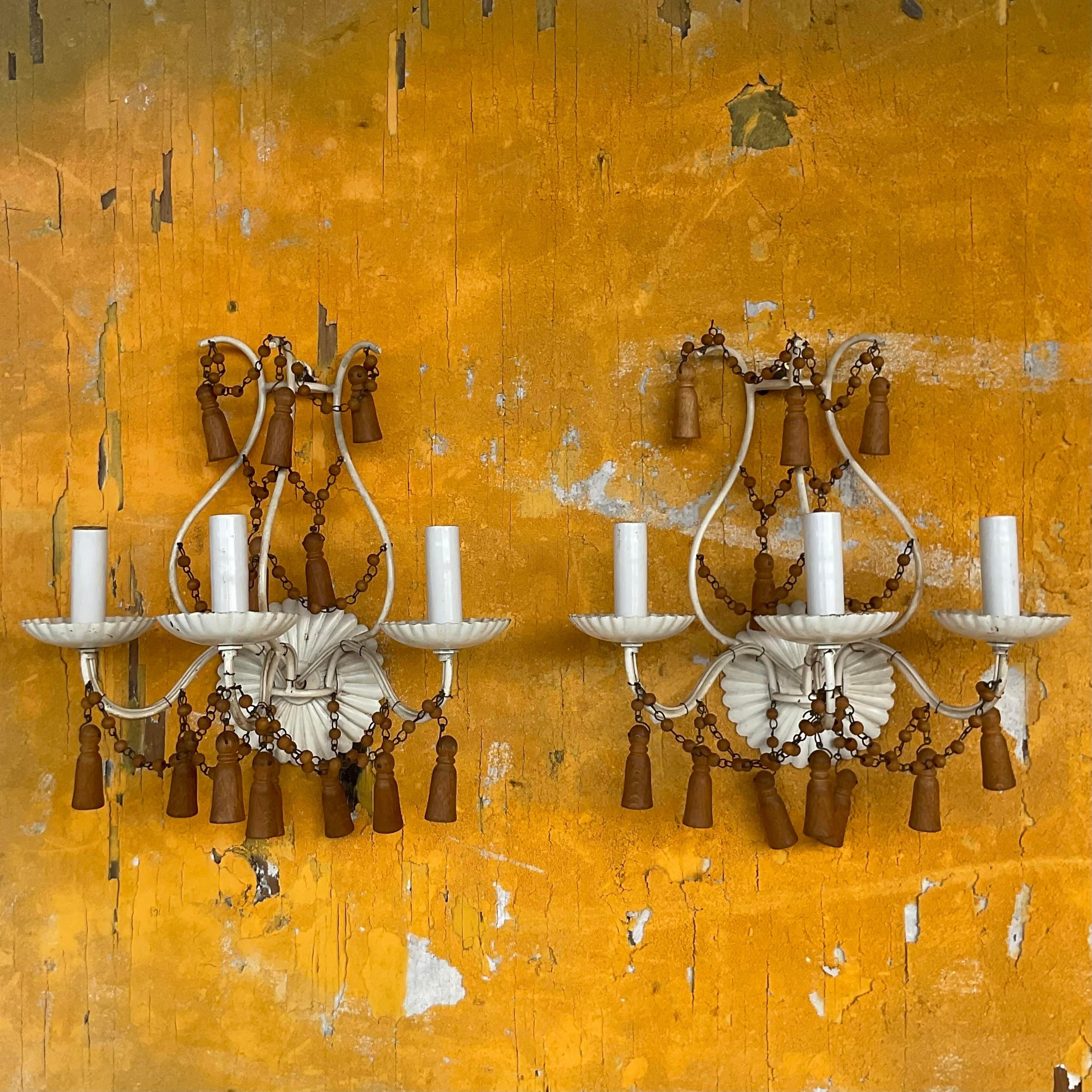 A fabulous pair of vintage Boho wall sconces. Chic white ruffled metal with the most amazing wood turned teardrop swag detail. A really special pair of lights. Acquired from a Palm Beach estate. 