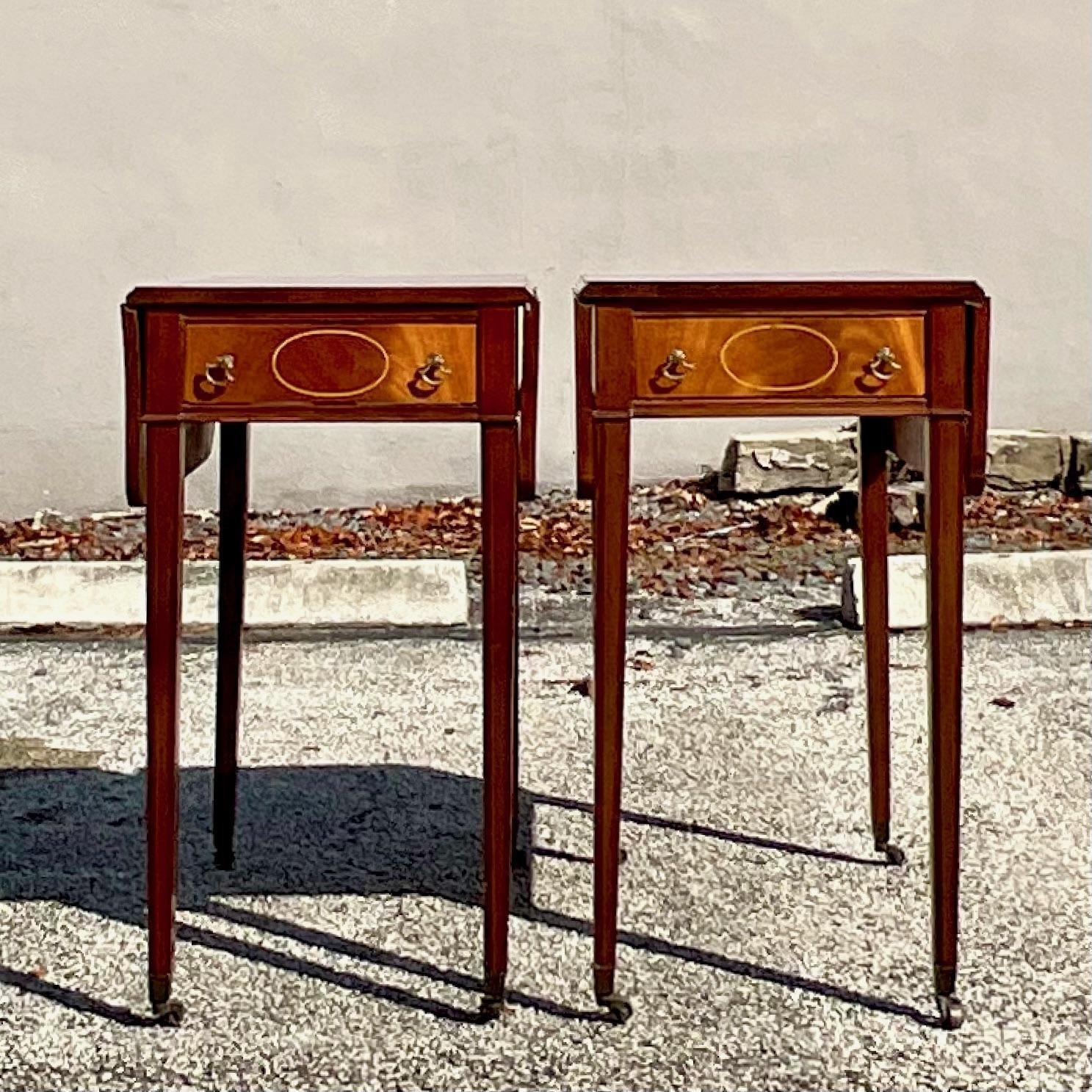 Exquisite pair of inlay mahogany pembroke tables featuring squared tapered legs on casters. This pair of pembroke tables will immediately elevate any space with a level of sophistication unmatched by many. The beauty is matched with functionality