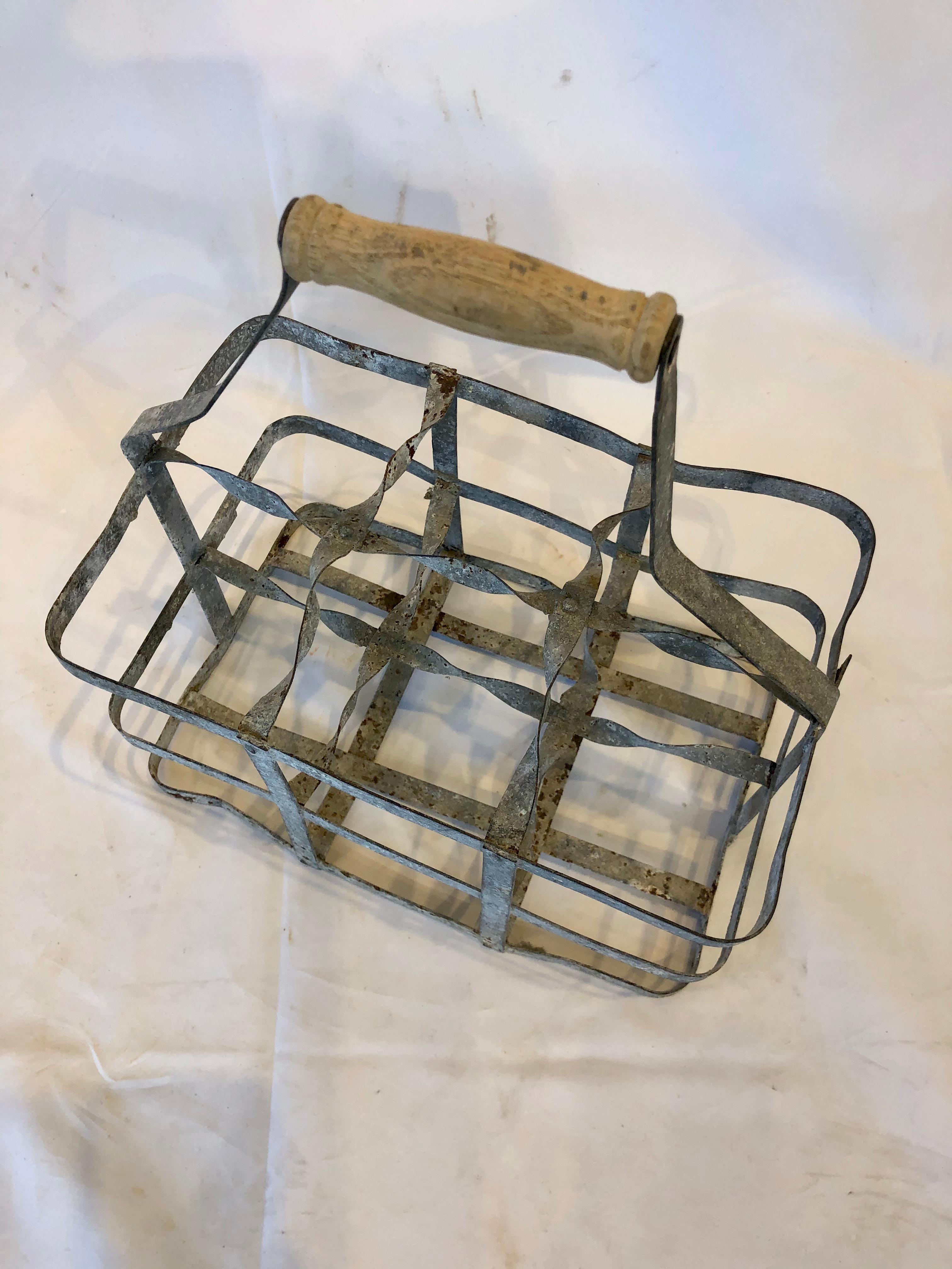 Early 20th century vintage French six bottle wine carrier basket from France. Antique french handmade wine bottle carrier rack for 6 bottles, made of metal with a wooden handle. Used by the french for carrying wine bottles when going to the wine