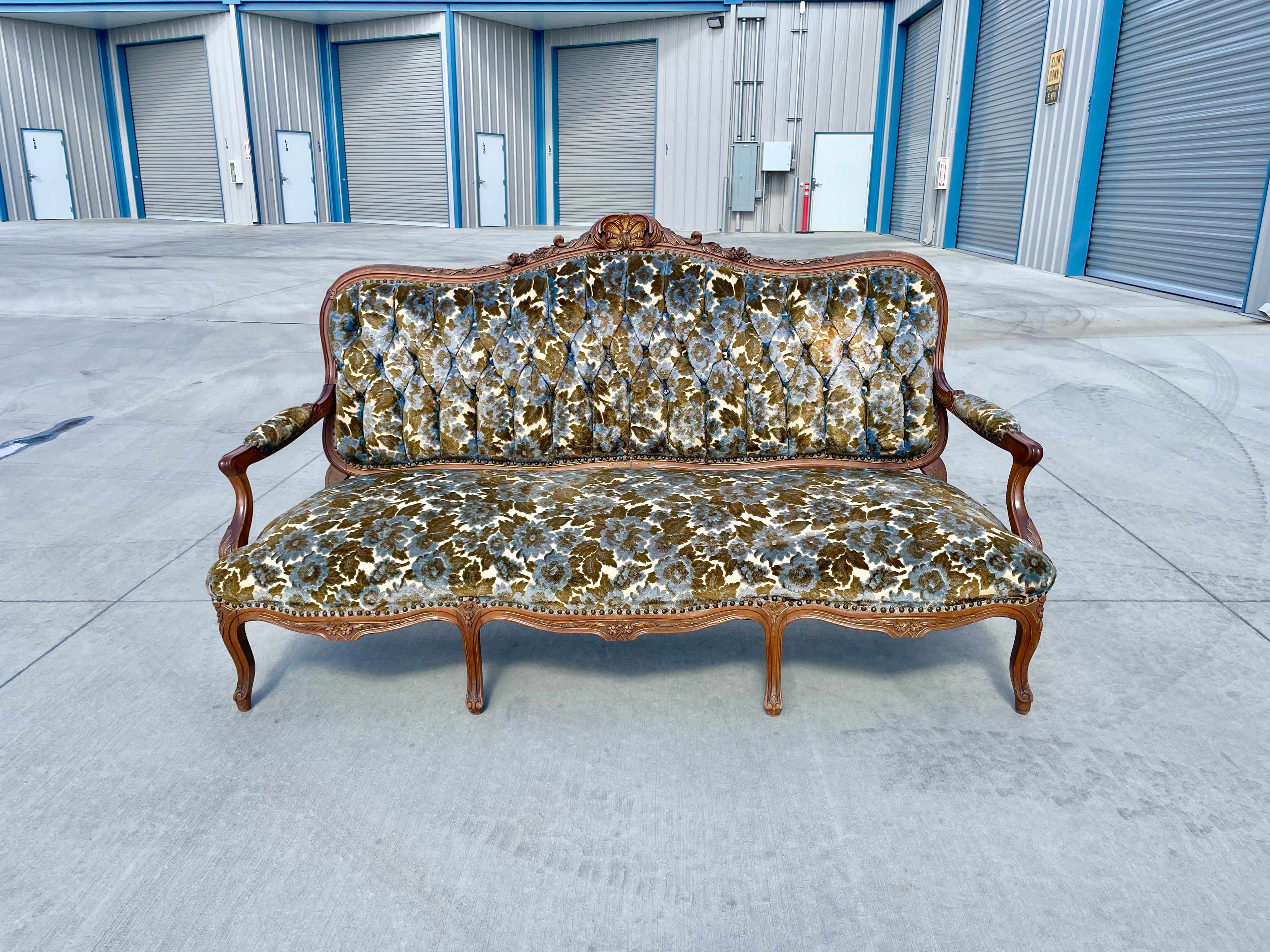 Vintage sofa was designed and manufactured in France circa the early 20th century. This beautiful sofa was styled after Louis XV; it features an oak frame with beautiful sculptural design surrounding the piece. The sofa also has flower pattern