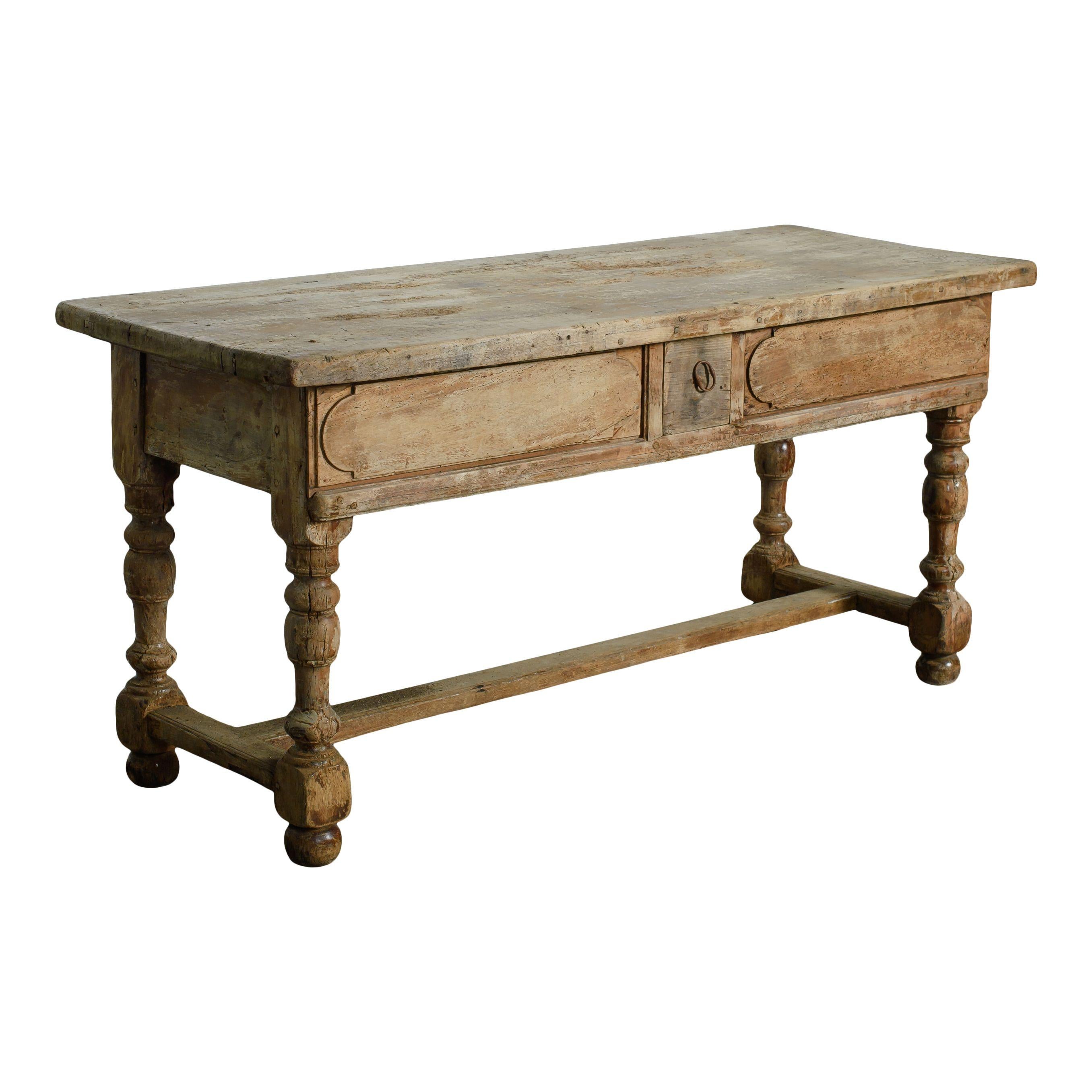 Vintage wood table with small drawer and spindle legs. The dark worn wood gives this piece a class vintage charm. The spindle legs are also a timeless vintage detail and the little drawer in the middle is a unique little touch. A desk that is sure