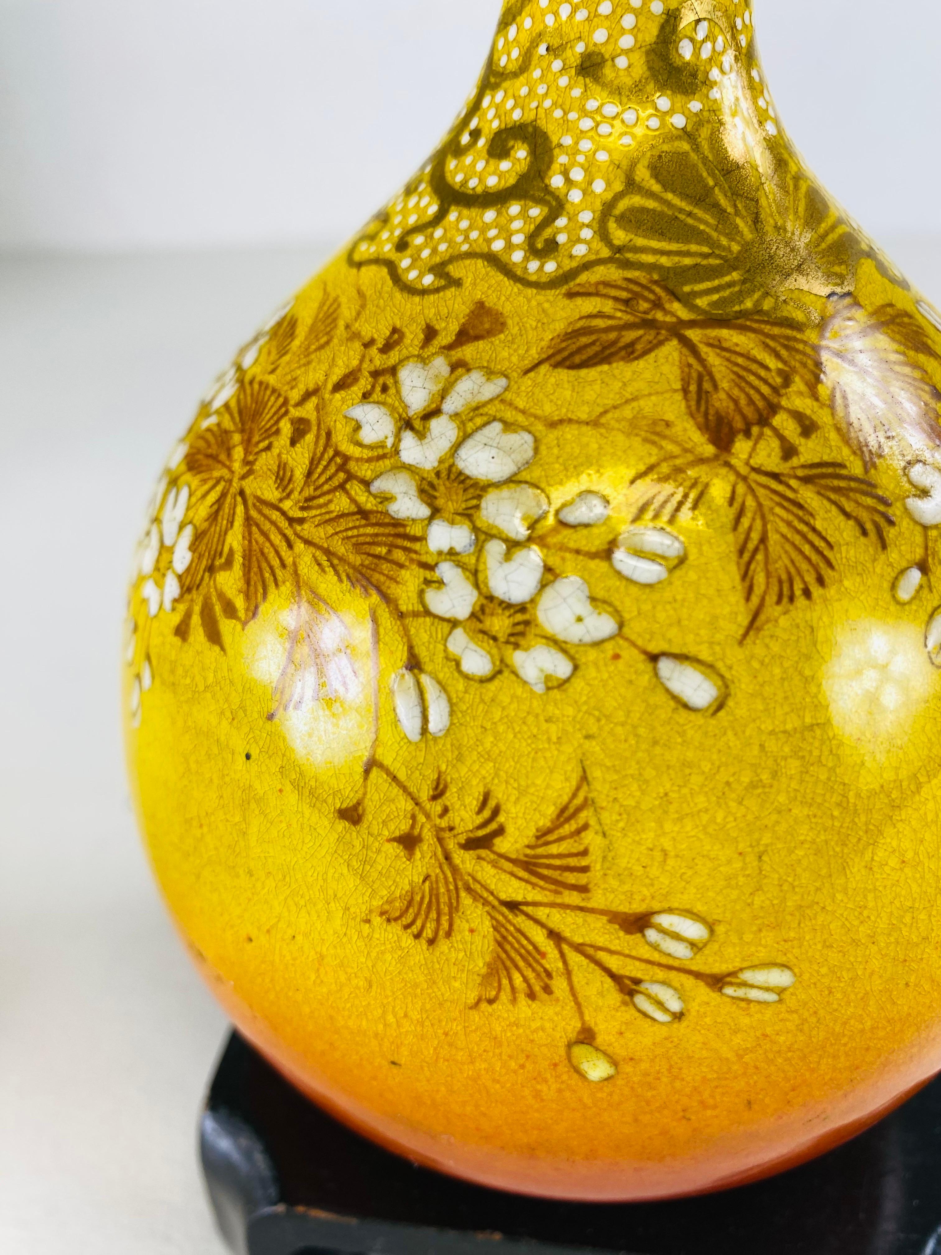 This is an early 20th century hand painted Chinese export vase with stand. This vase is hand painted in beautiful tones of mustard yellow, cream and gold. The vase comes with a black orientalist stand and has no makers mark.