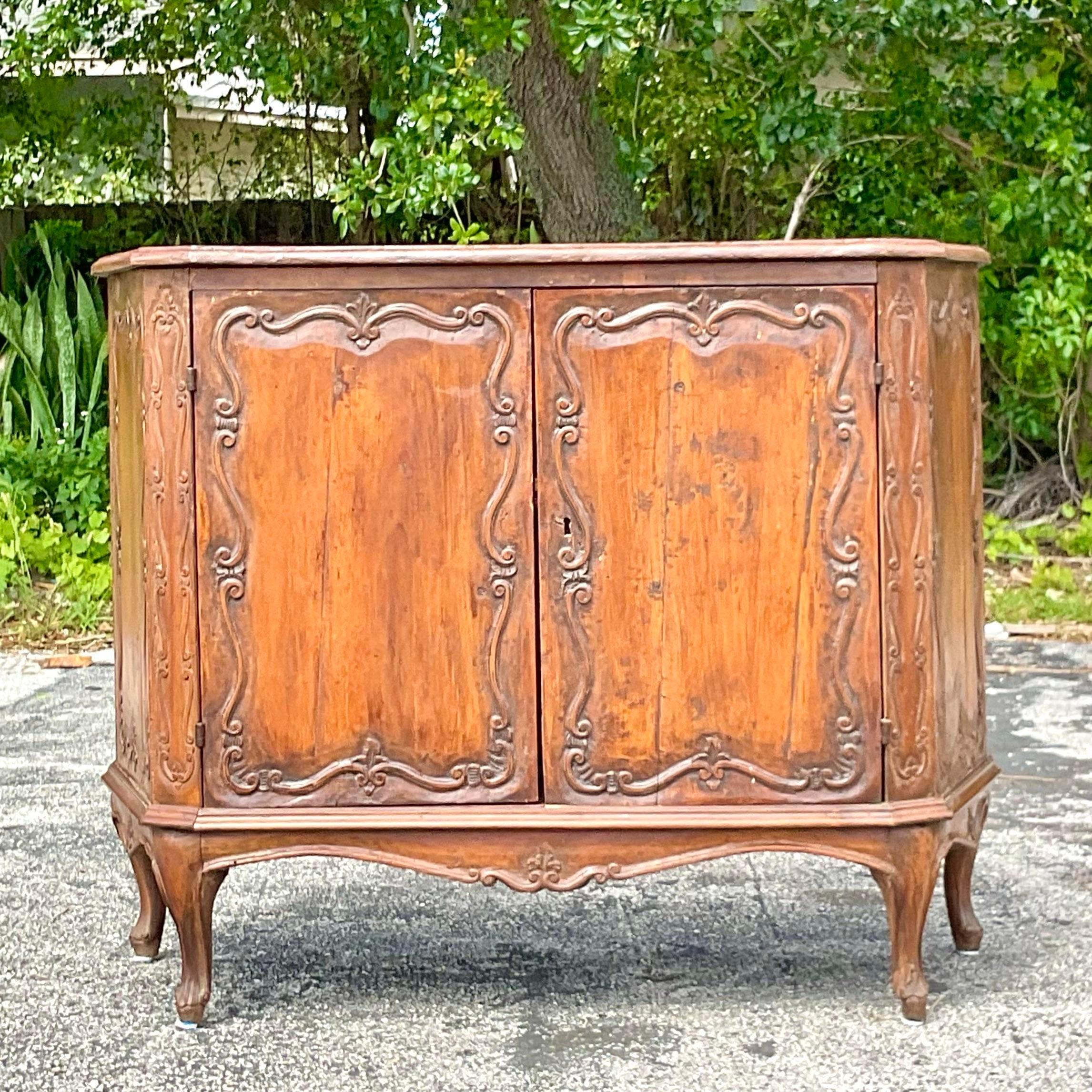 Old World Charm, American Appeal: Vintage Italian Carved Console Cabinet. Elevate your space with European elegance and American flair, showcasing intricate carving and timeless craftsmanship for a statement piece that transcends borders