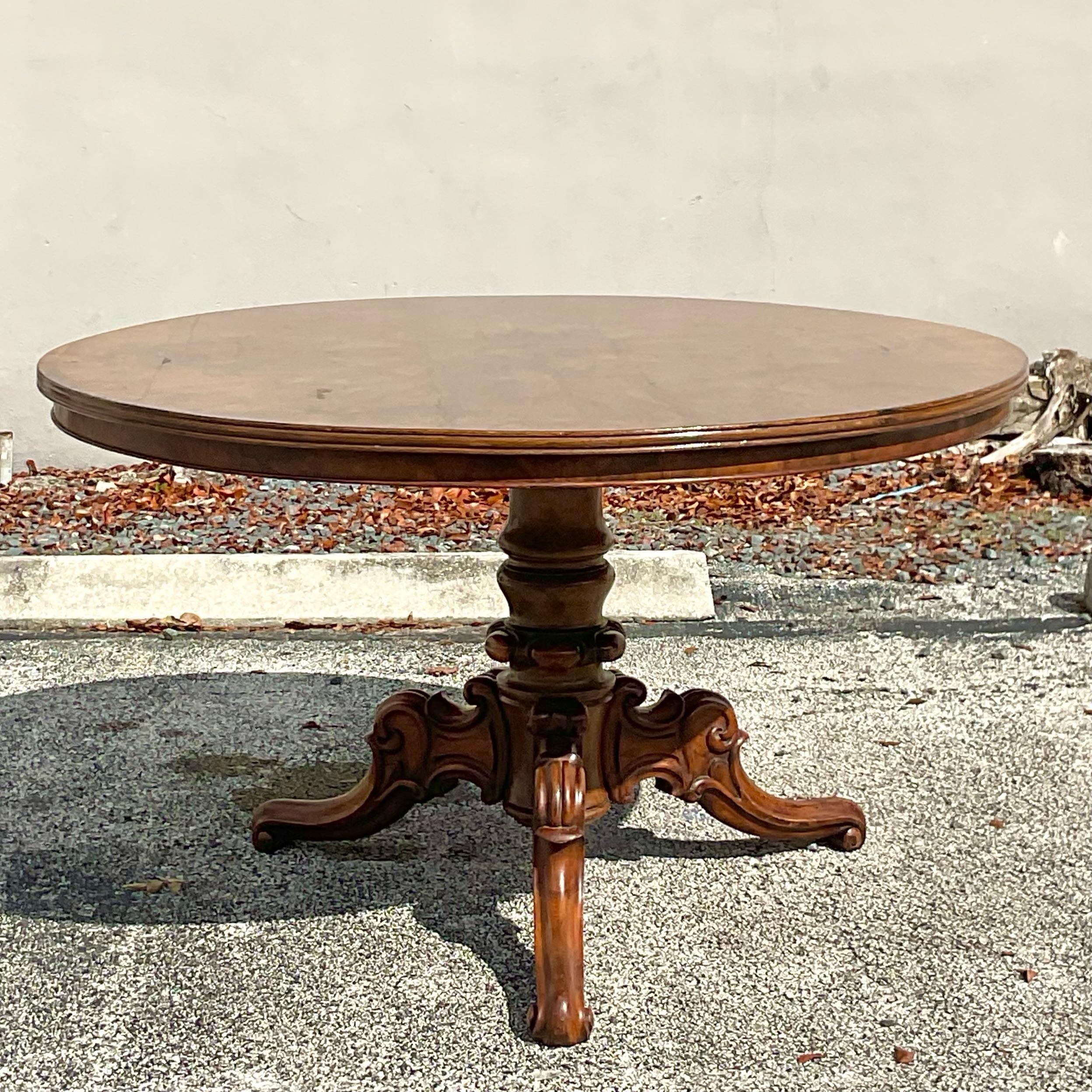 Fine quality mahogany round pedestal center or dining table. The top has gorgeous visible wood graining and the pedestal and its four legs are all intricately carved with impeccable attention to detail. Gorgeous old world addition to any space.