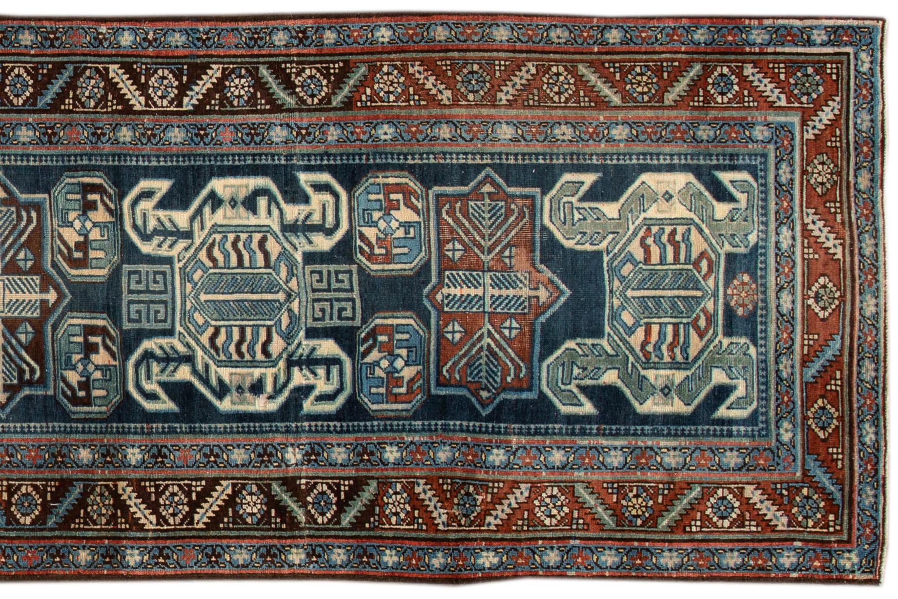 Beautiful hand knotted antique Persian wool runner rug, with a blue field, brown and ivory accents in a geometric multi medallion design. 

This rug measures 3' 5