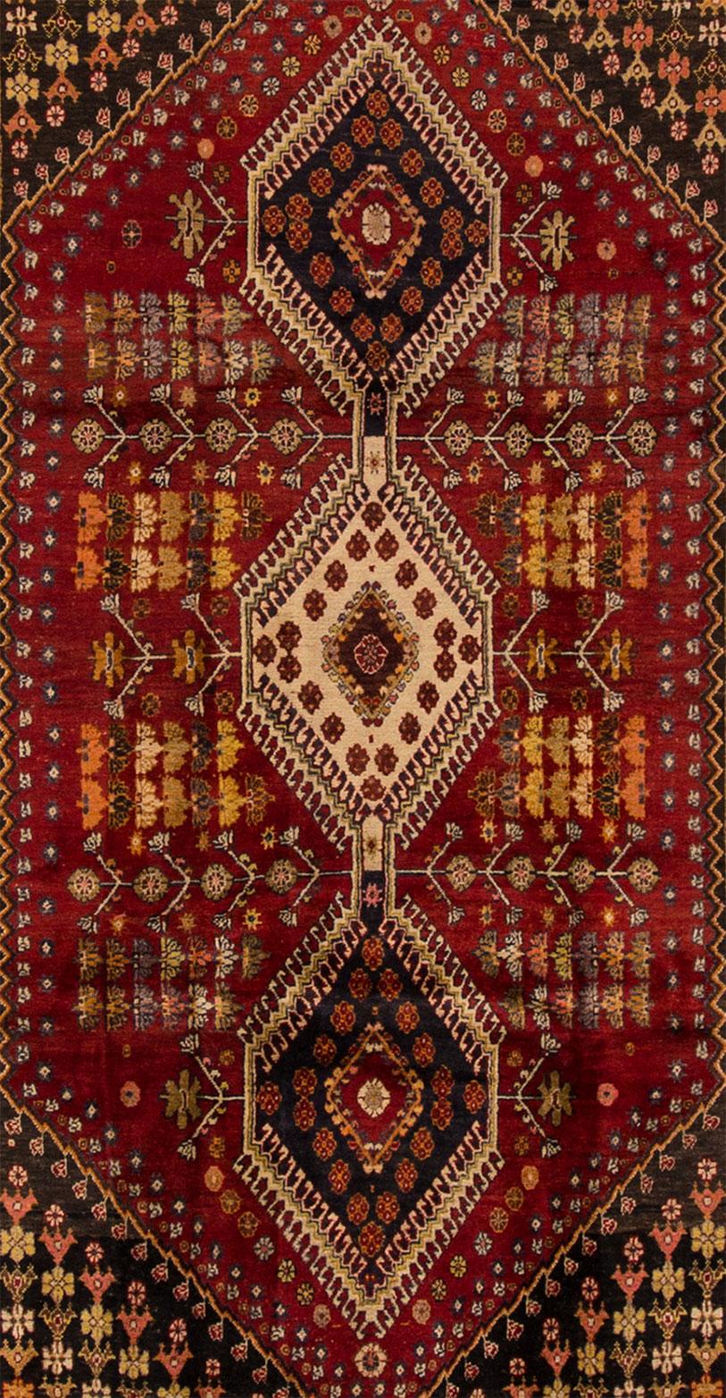 Beautiful vintage Shiraz rug, hand knotted wool with a rust field, orange and ivory accents, in a center multi medallion design.
This rug measures 4' 0