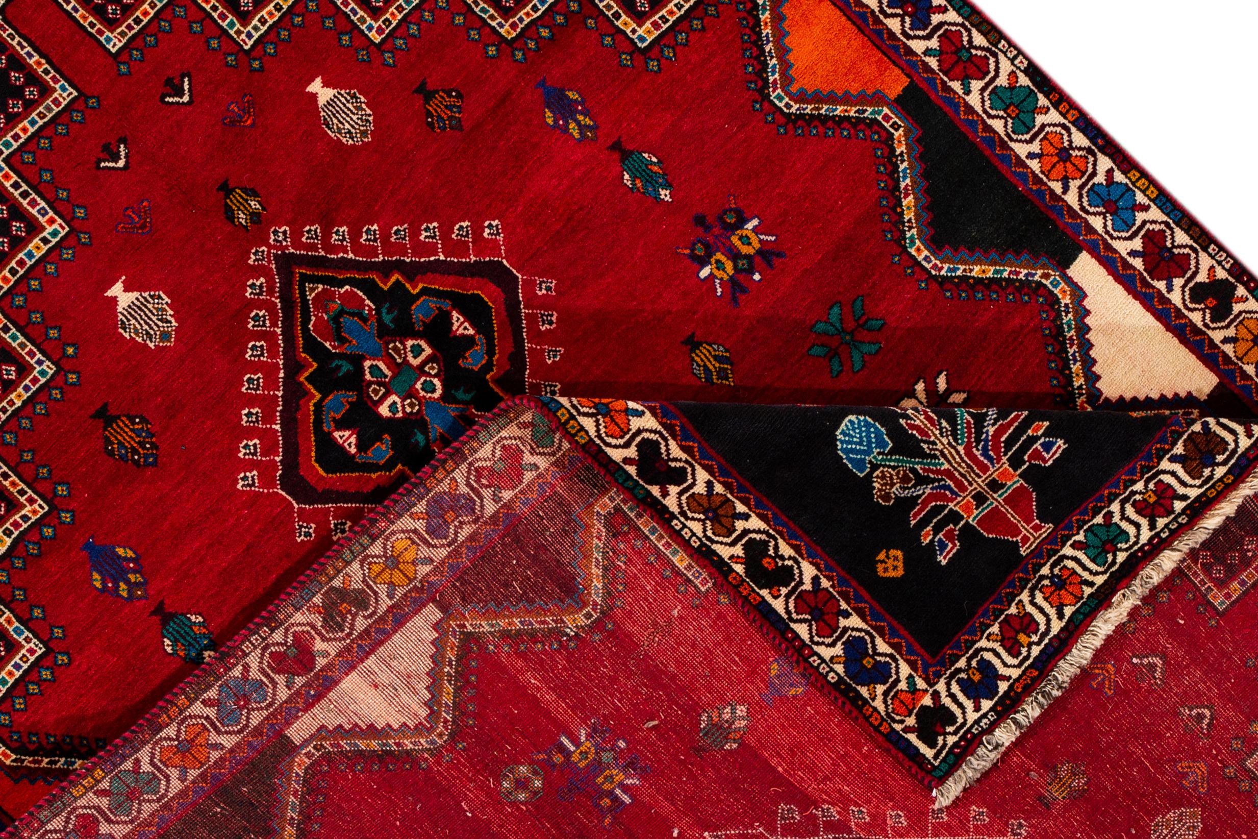 Schöne Vintage Shiraz Teppich, handgeknüpft Wolle mit einem roten Feld, schwarz und Elfenbein Akzente in einem Zentrum Multi Medaillon Design.
Dieser Teppich misst 5' 9