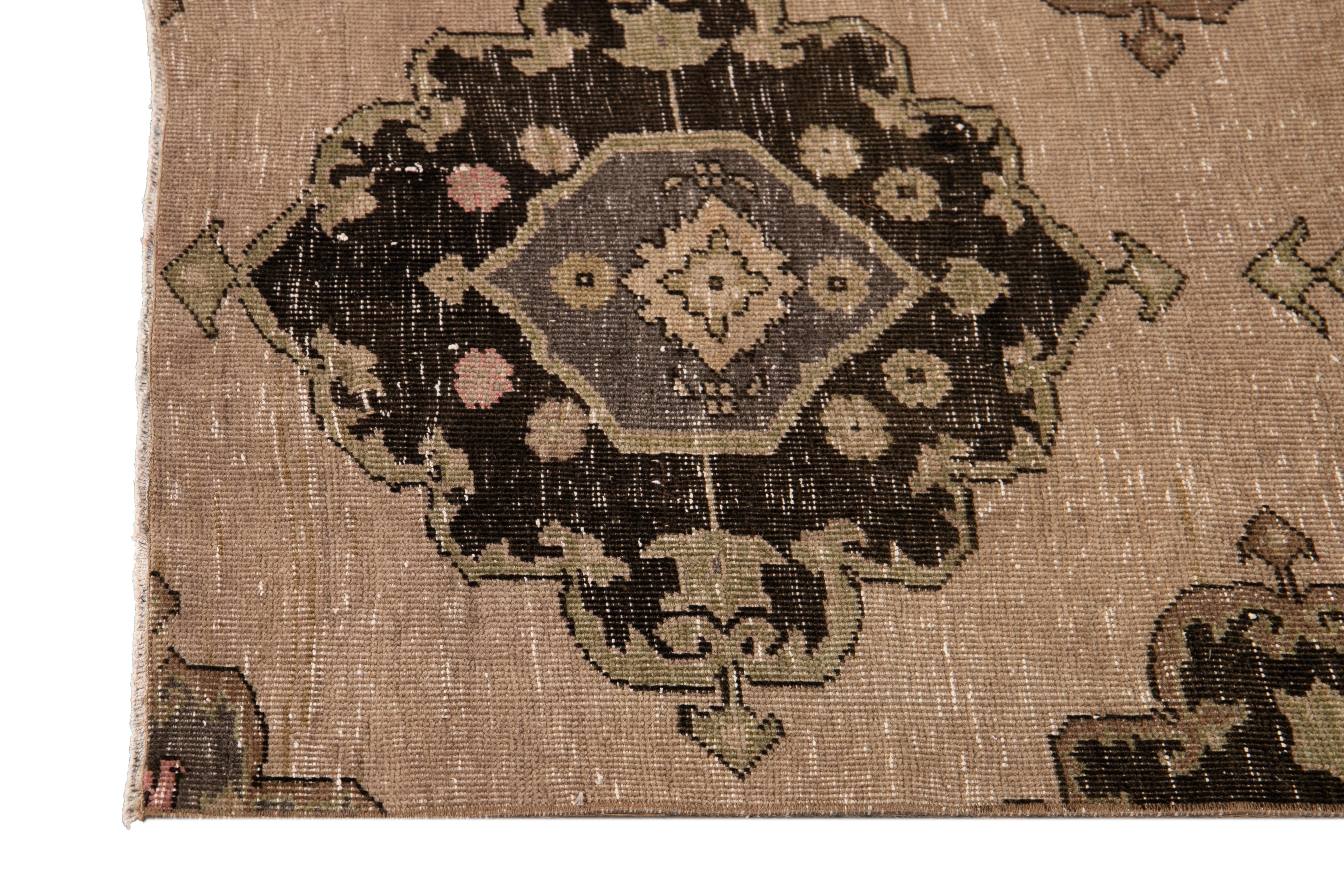 Beautiful antique wool runner rug, hand knotted wool with a dark tan field, light and dark brown accents in an allover muti medallion geometric design

circa 1930

This rug measures 2' 10