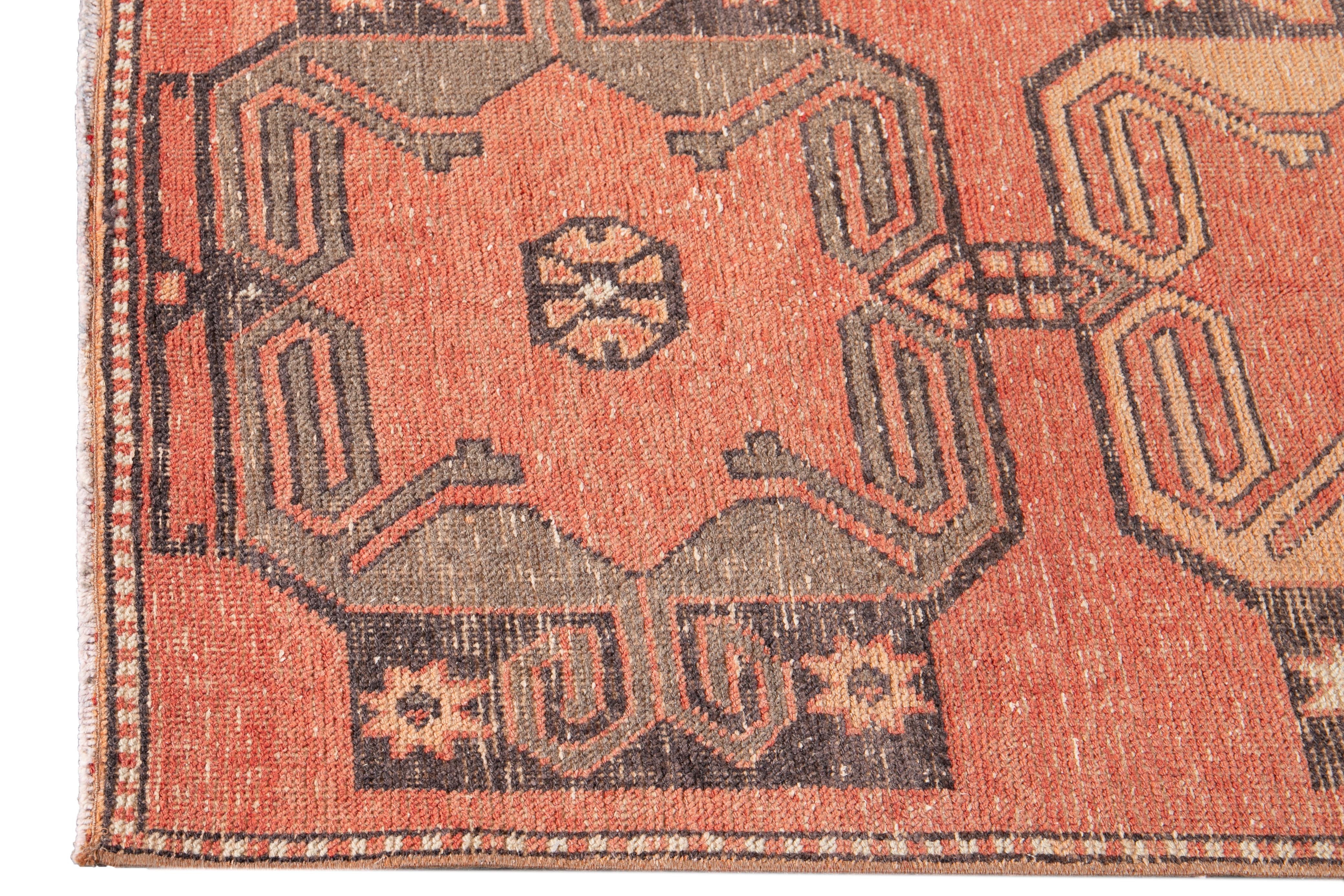 Bellissimo tappeto runner turco antico, realizzato a mano in lana con un campo ruggine chiaro, accenti grigi e avorio in un disegno geometrico a più medaglioni.

Questo tappeto misura 3' 0