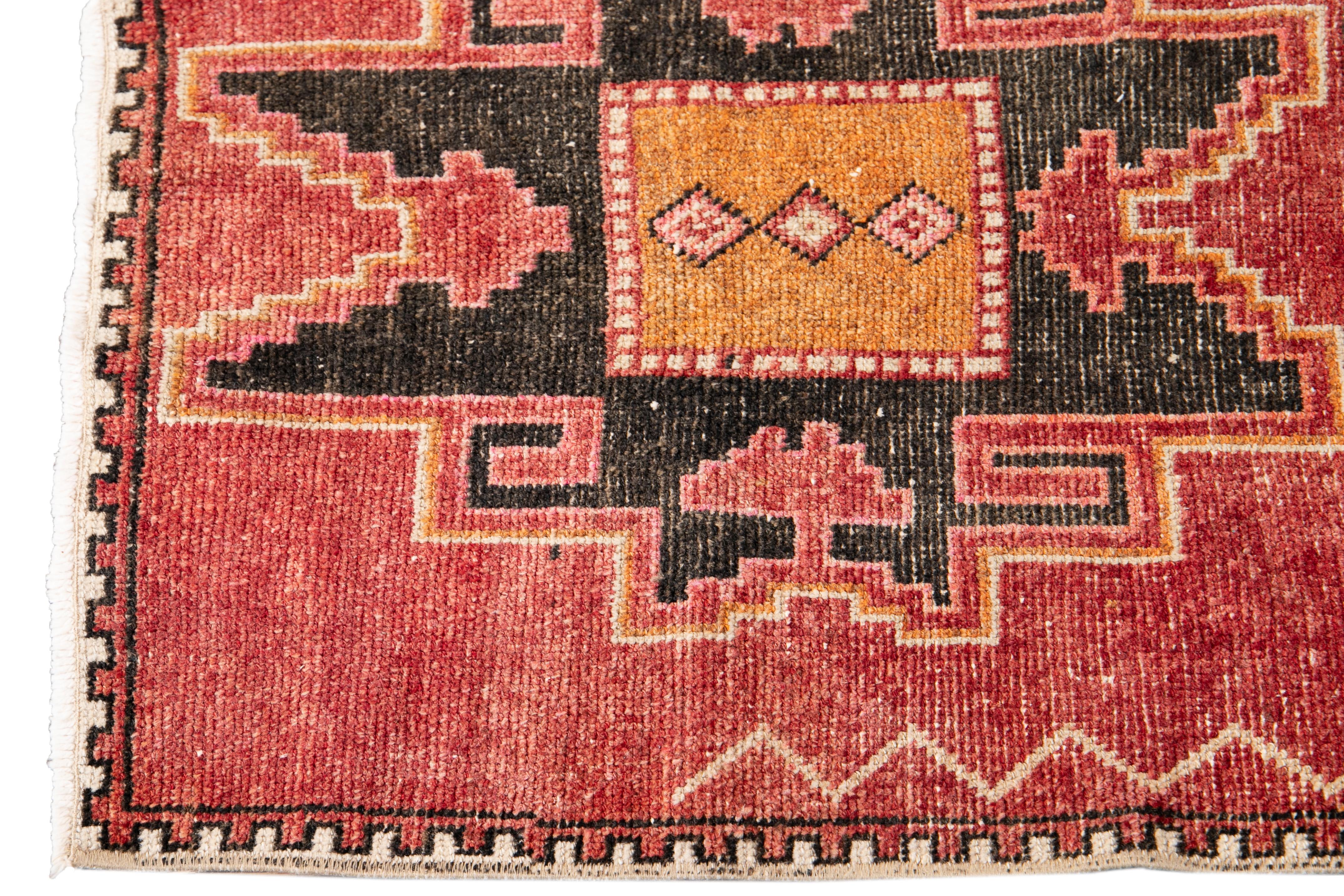 Beautiful Antique Runner rug, hand knotted wool with a light rust field, orange and dark brown accents in an allover multi medallion geometric design.

This rug measures 2' 8