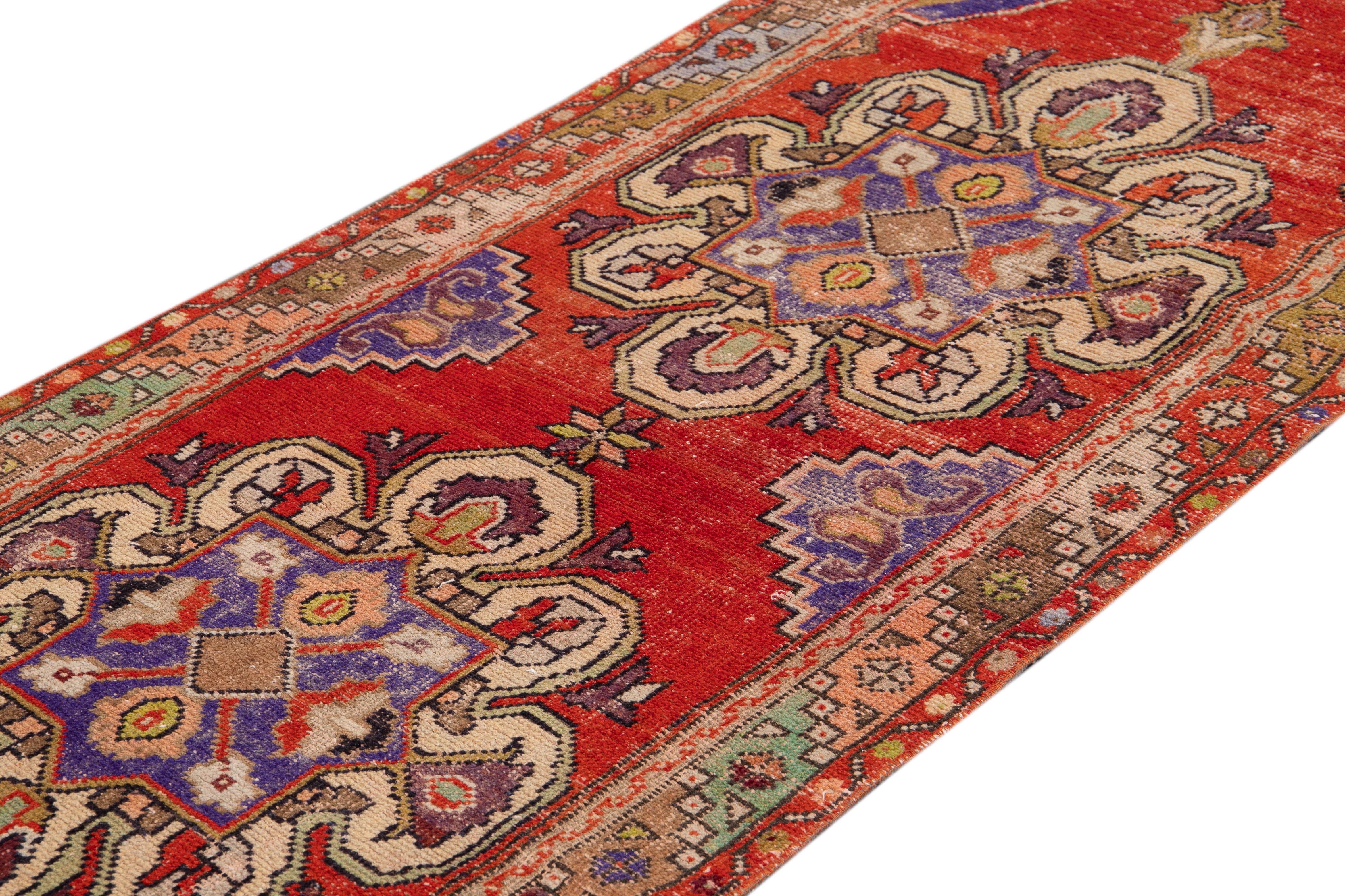 Beautiful antique runner rug, with a red field, ivory and purple accents in Classic multi medallion design.

This rug measures 3' 2