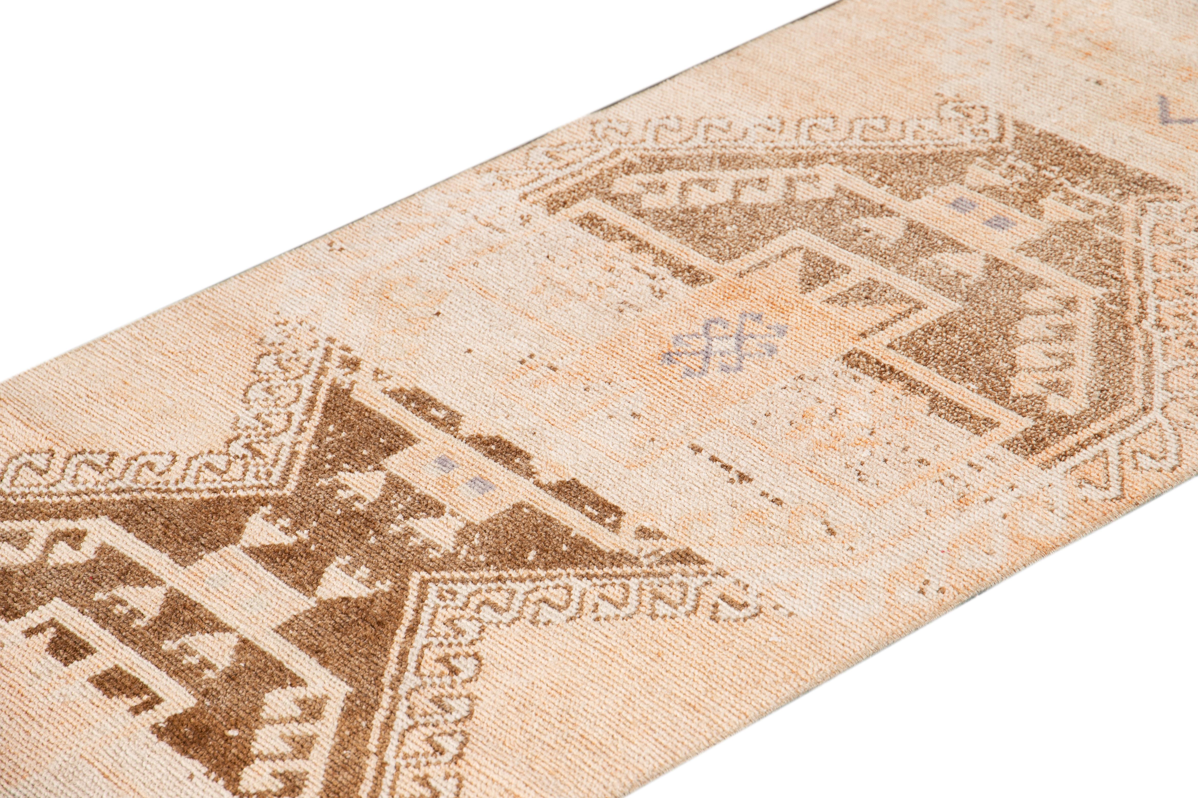 Beautiful Antique Runner rug, hand knotted wool with a light peach field, tan and light brown accents in an all-over multi medallion geometric design.

This rug measures 2' 7