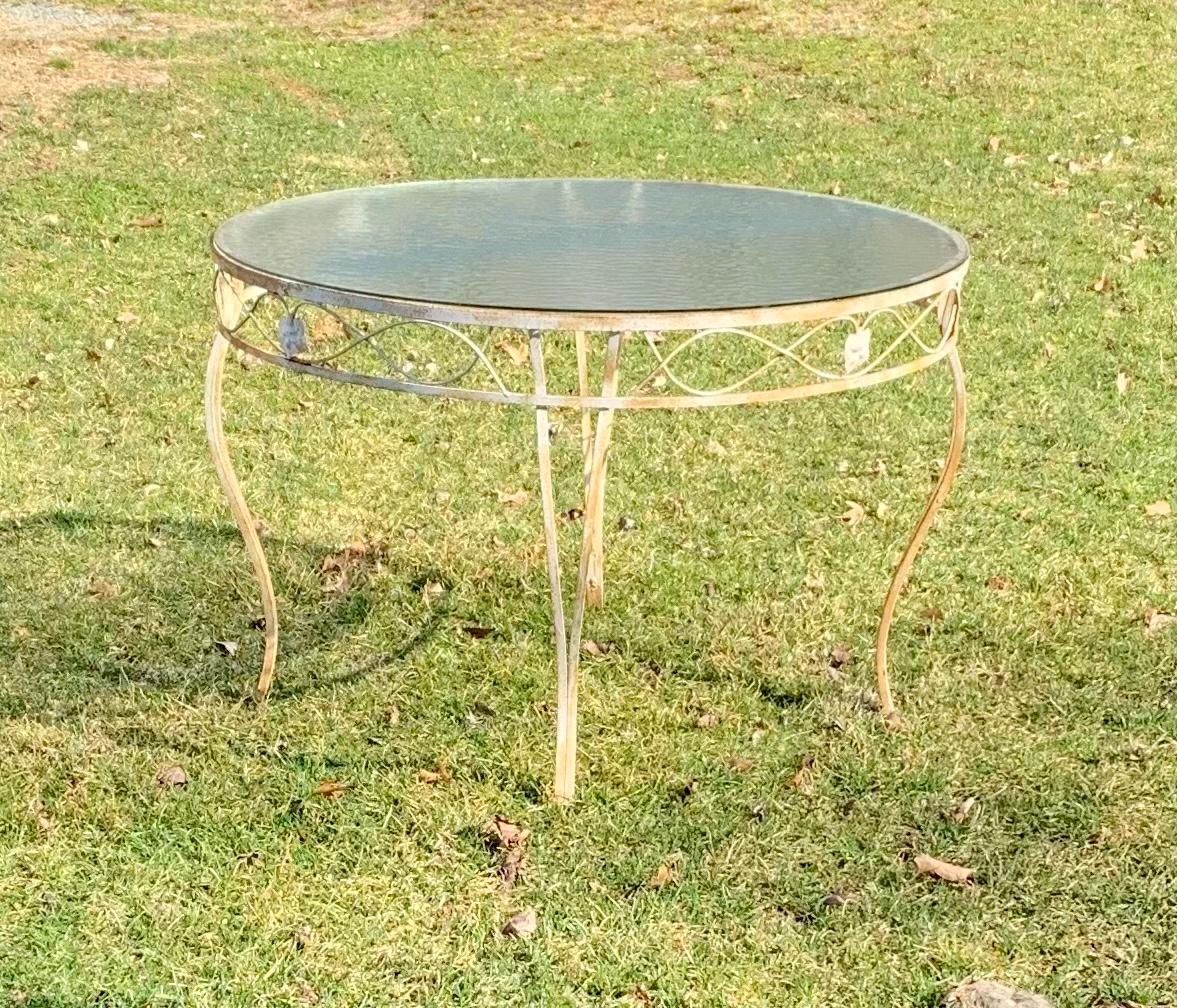Early 20th century vintage wrought iron table

This solid and heavy duty wrought iron table features a generous 48 inch Glass Top perfect for entertaining 4 guests. Pair with coordinating available chairs sold separately that will look beautiful