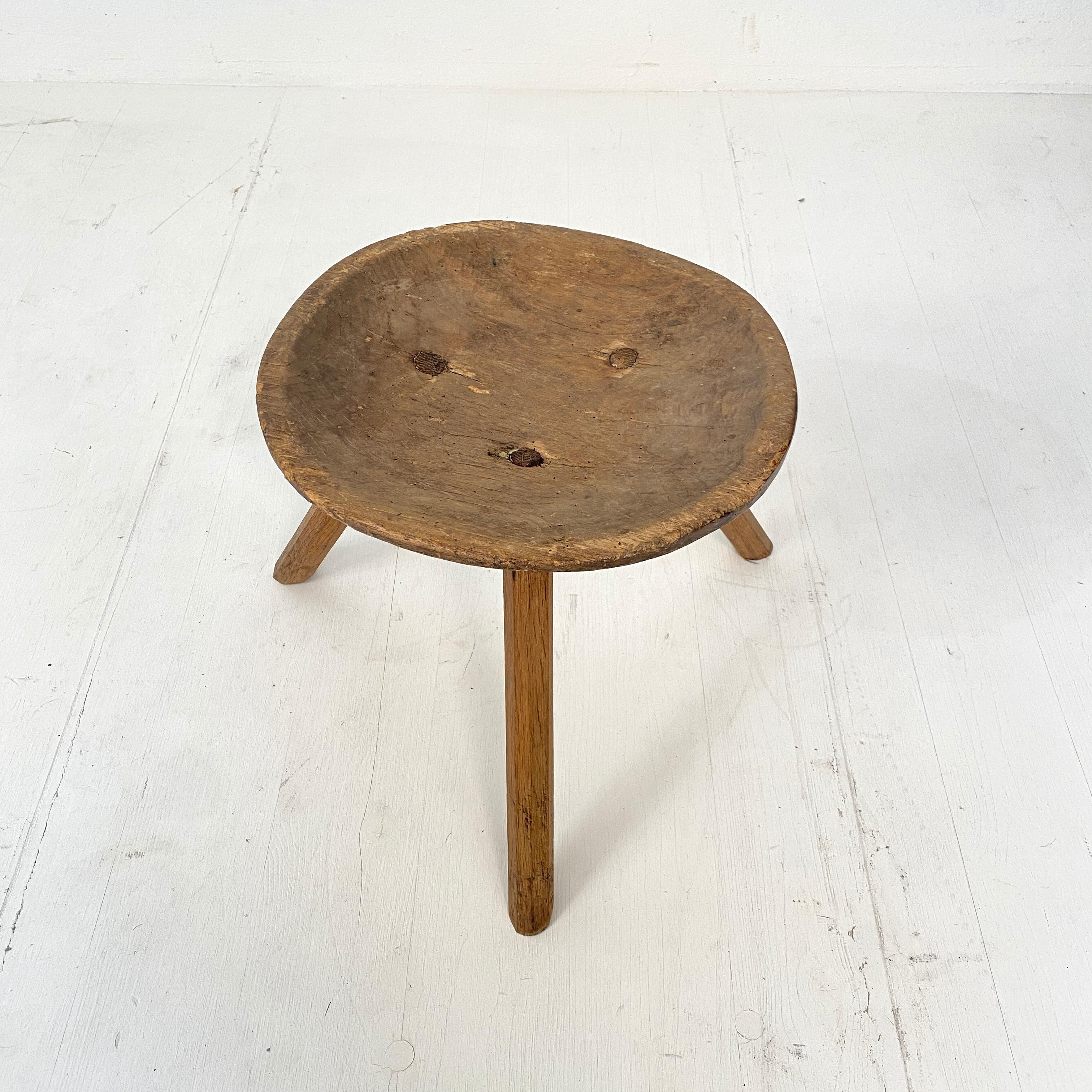This primitive milking splayed leg wood stool was made circa 1910. The seat is out of a solid piece of ash and the legs are made out of beech. The seat is beautifully carved out of one single piece.
It has this fabulous Wabi Sabi look and beautiful
