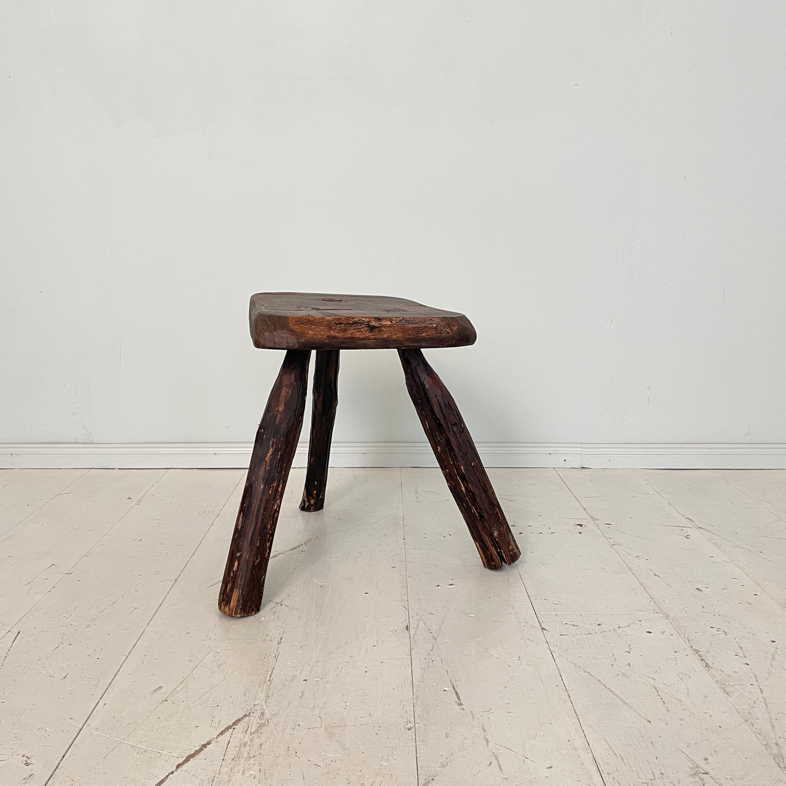 This primitive milking splayed leg wood stool was made circa 1910. The seat is out of a solid piece of ash and the legs are made out of pine. 
It has this fabulous Wabi Sabi look and beautiful patina. It is in its original condition. 
A unique