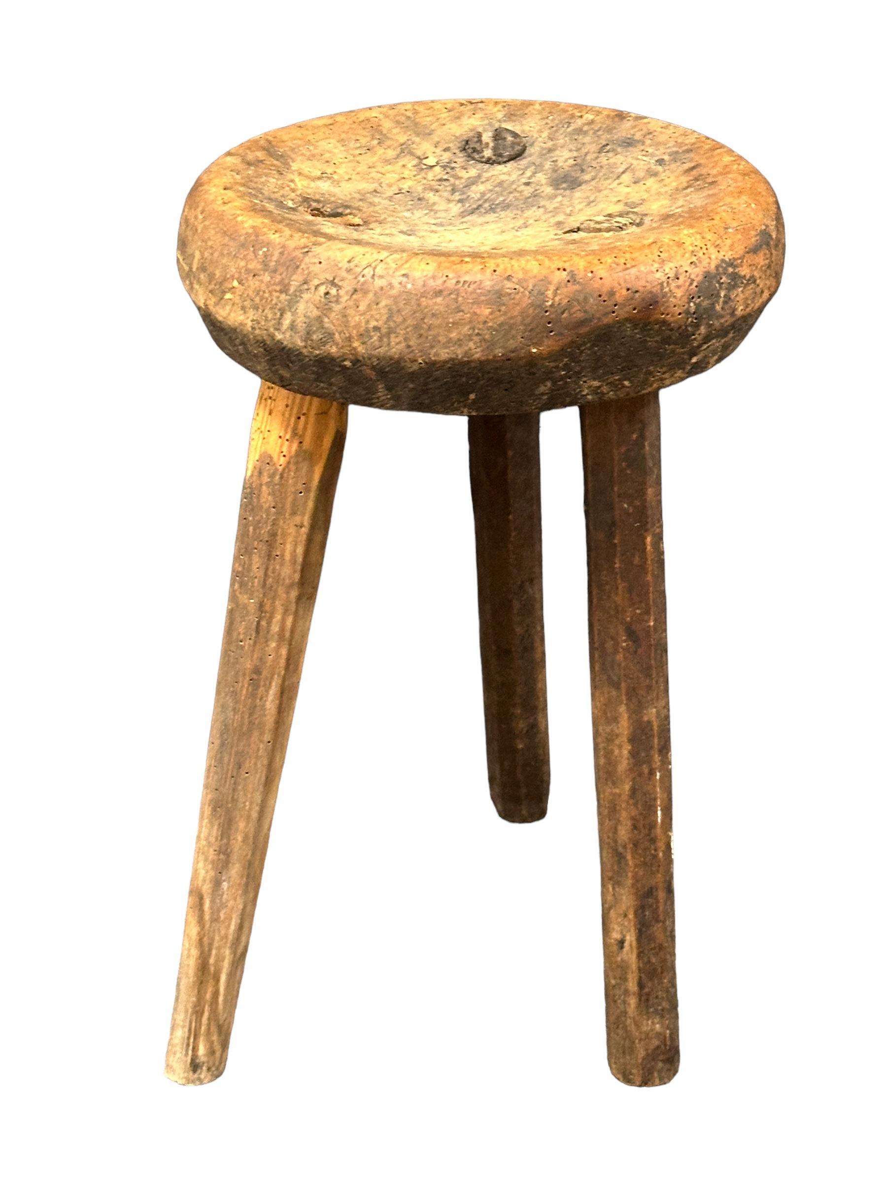 This early 20th century wabi sabi 3 leg workshop stool from Germany is an excellent example of this style. The piece has a square, rustic-looking seat made of wood and is supported by three legs. The stool has a simple, understated design which is