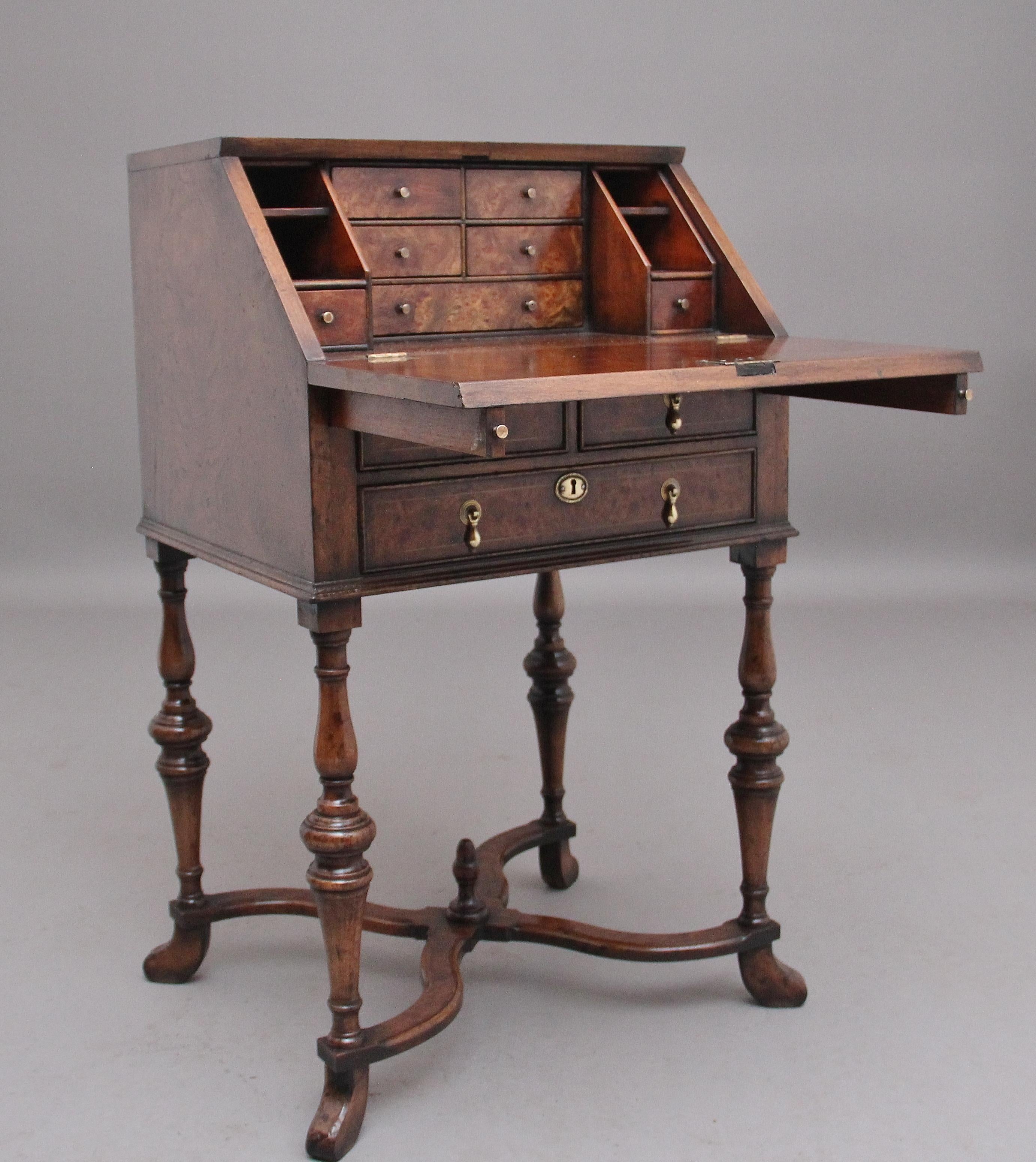 Early 20th Century walnut and elm bureau in in the Queen Anne style, having a lovely figured and inlaid fall which opens to reveal various drawers and compartments and a solid top writing surface, two short over one long drawer below with original