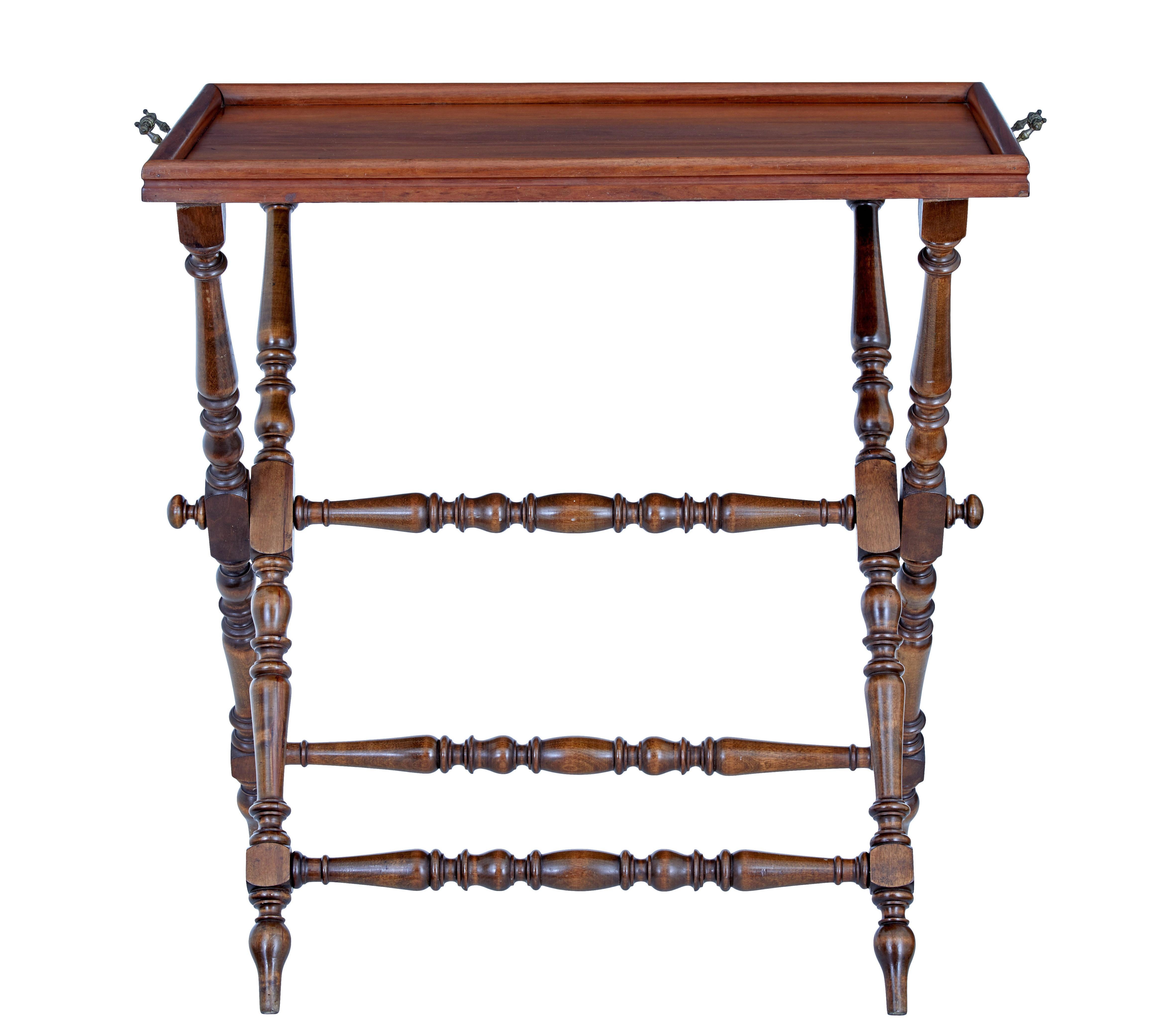 Early 20th century walnut butlers tray on stand circa 1920.

Good quality piece of practical furniture that can be stored away when not in use.

Rectangular top with raised moulded border, fitted with ornate carrying handles.  Tray top stands on a