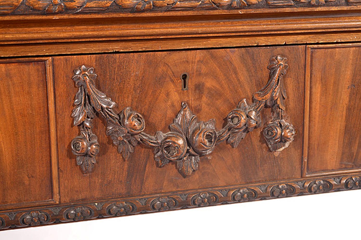 A good quality early 20th century walnut Chippendale style side table.

The figured and shaped top with a moulded and carved edge.

The three cock beaded drawers with mahogany linnigs.

The central drawer with an applied floral swag, is
