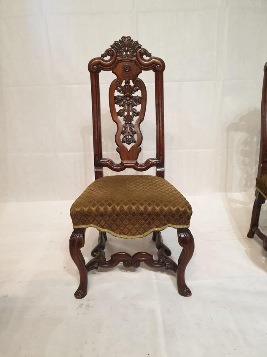A finely carved pair of early 20th century walnut hall chairs in the William and Mary style, circa 1930.