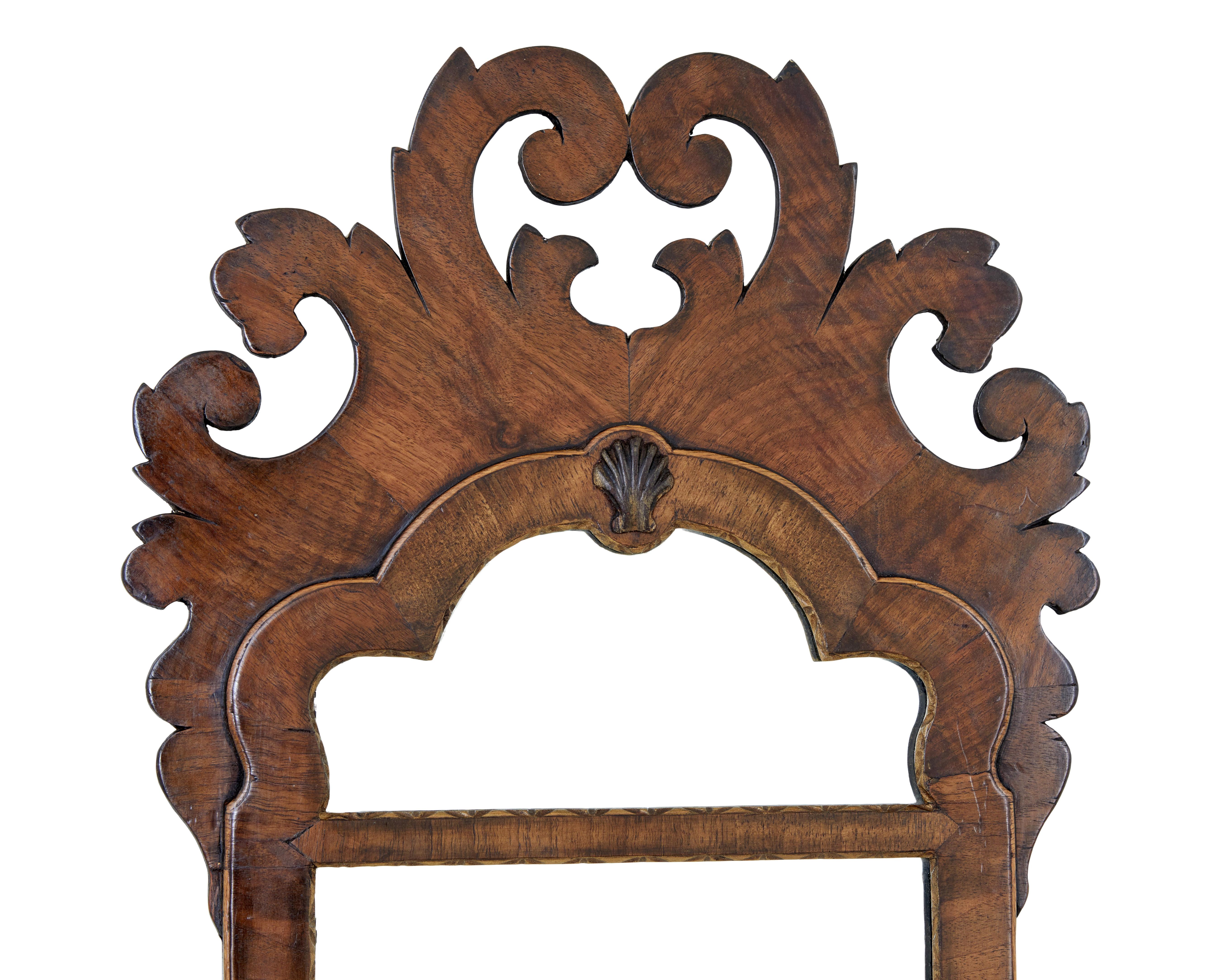 Early 20th century walnut rococo revival mirror circa 1910.

Good quality rococo revival mirror, which takes it's inspiration from the George II period.

Fret cut mirror with swags, cross banding and a central shell.  2 part mirror with further