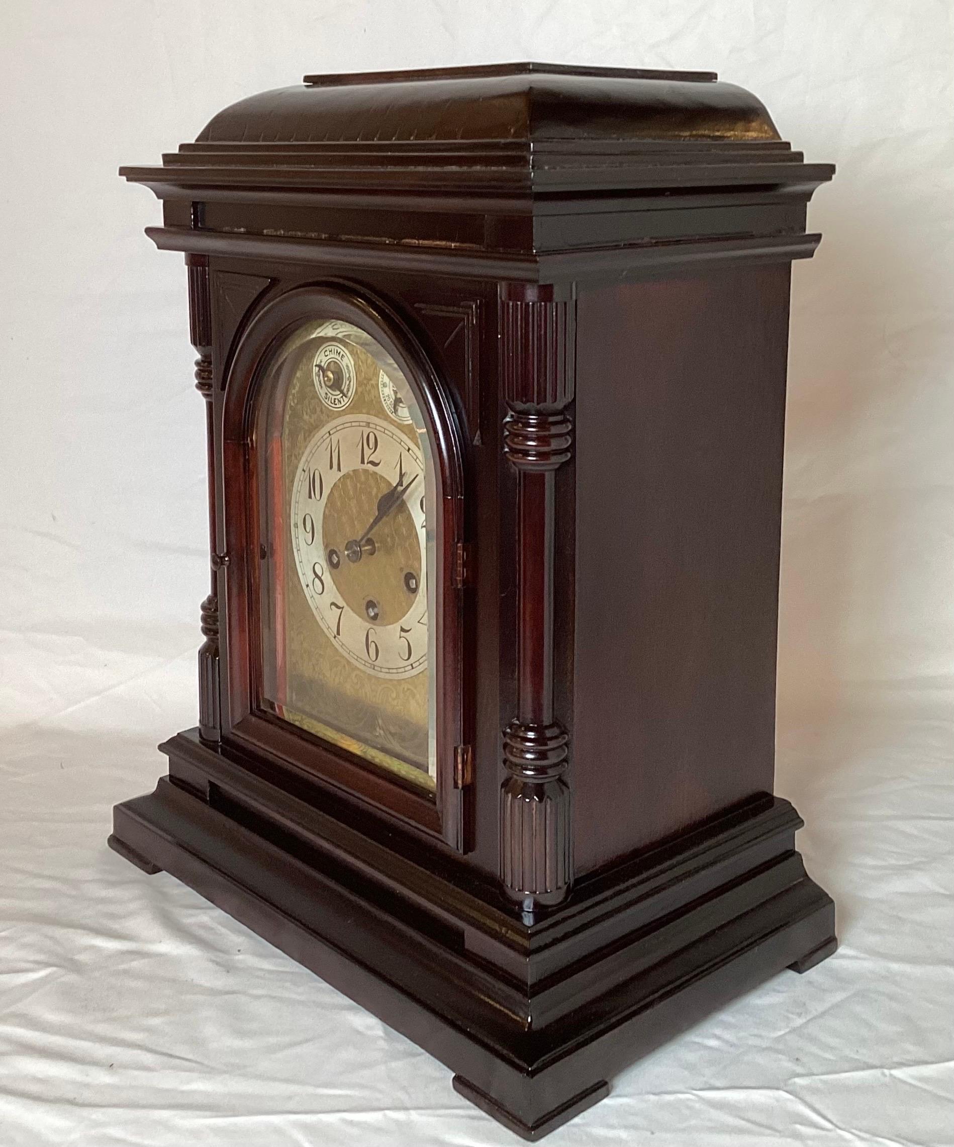 Elegant mahogany cased bracket clock with beveled glass front. The clock, with German movement with Westminster chime on each quarter hour and strike at the hour. The case has been refinished and looks beautiful on the mantle or case piece.. Circa