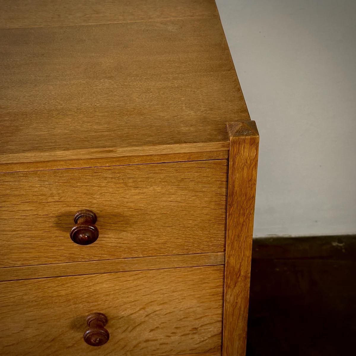 Cassettiera in rovere bianco massiccio inglese dei primi del Novecento di Heal's of London. Questo pezzo poggia su quattro gambe quadrate e presenta tre cassetti senza fronzoli con maniglie originali in legno di quercia tornito, che mostrano linee