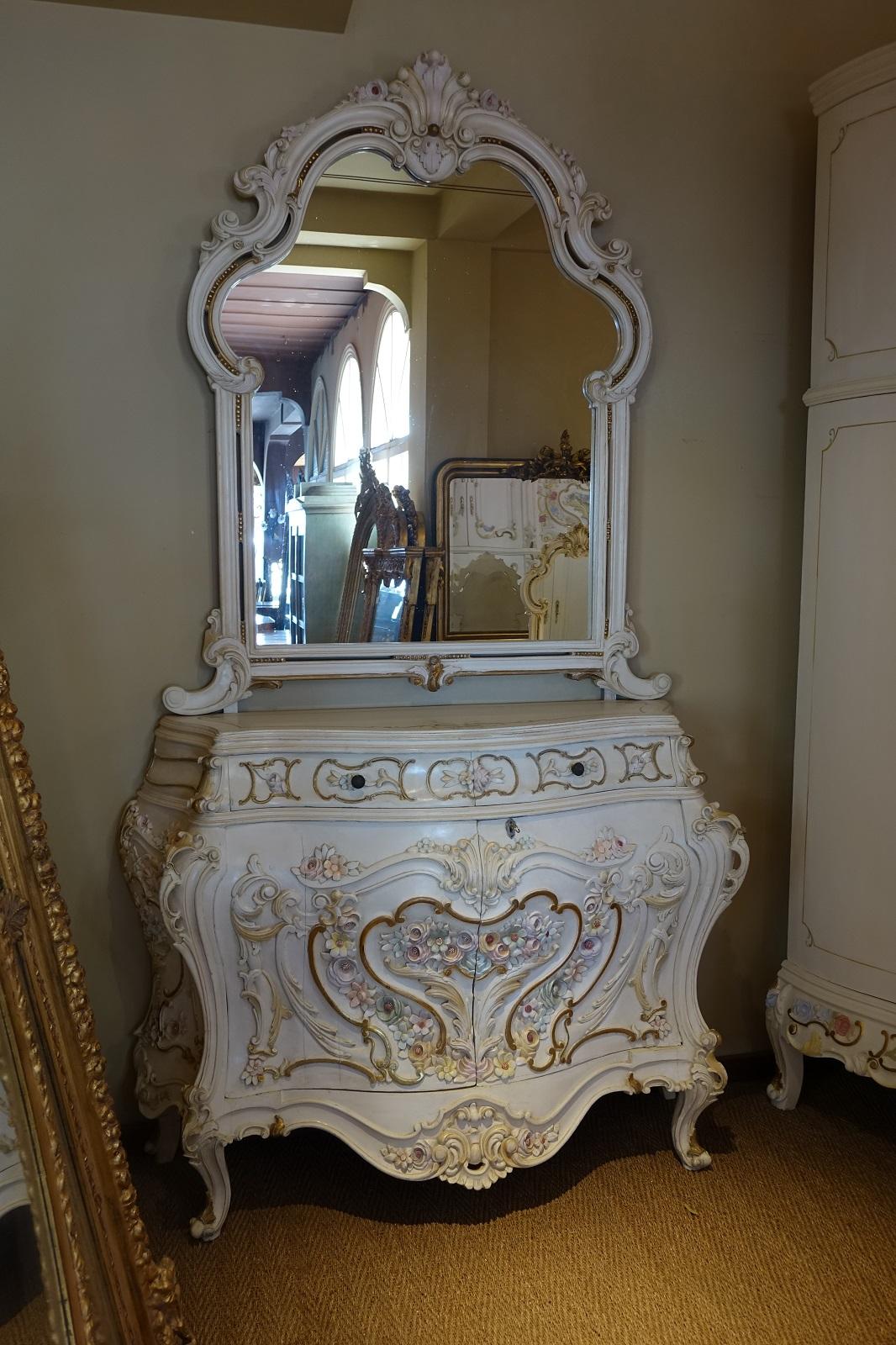This is a unique Italian early 20th century a painted complete bedroom set, very impressive by its size and the quality of the carving.
The set is composed by a king-size bed, two bedside tables, a large armoire with 12 doors and a vanity.
