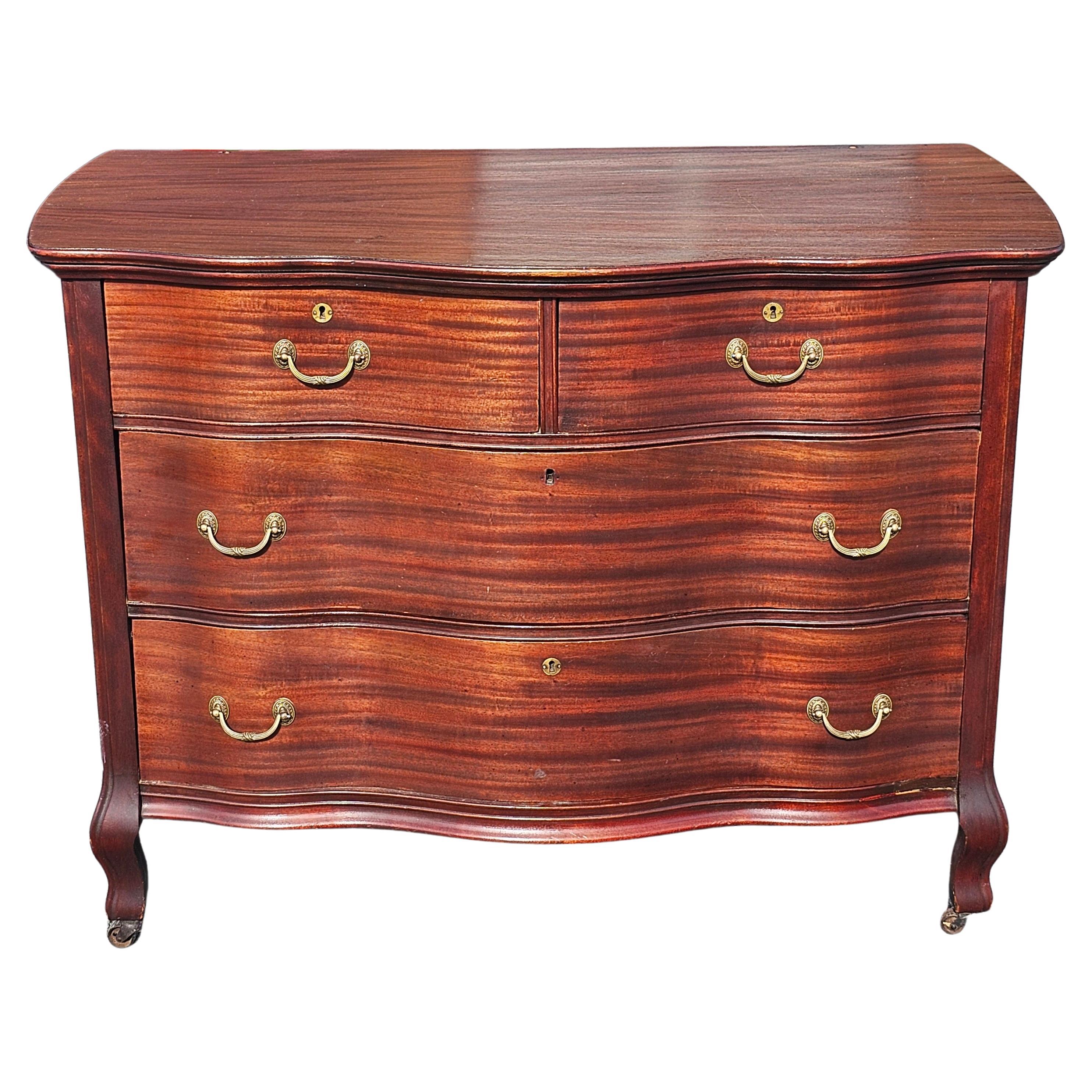 An Early 20th Century Widdicomd Solid Genuine Tiger Mahogany Serpentine front commode Chest of drawers on Wheels.  Deep Dovetail drawers working flawlessly. Matching mirror available in a separate listing. Measures 45