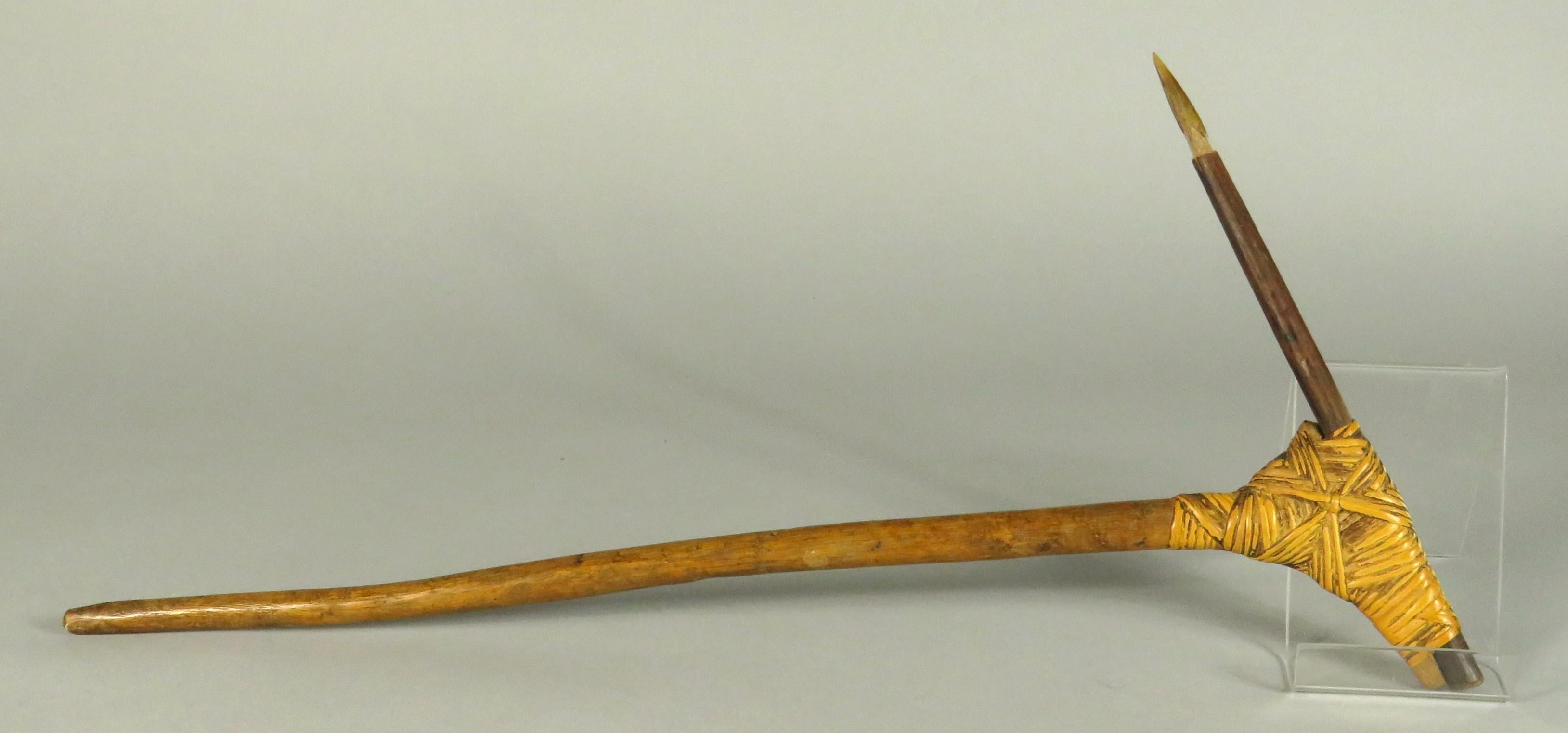 This early 20th century fighting implement originates from the Lowland rainforest of the Asmat Regency, Brazza River district of Southern Papua New Guinea. Showing a hardwood stake bound to a wood handle with rattan caning, the tip had been fitted