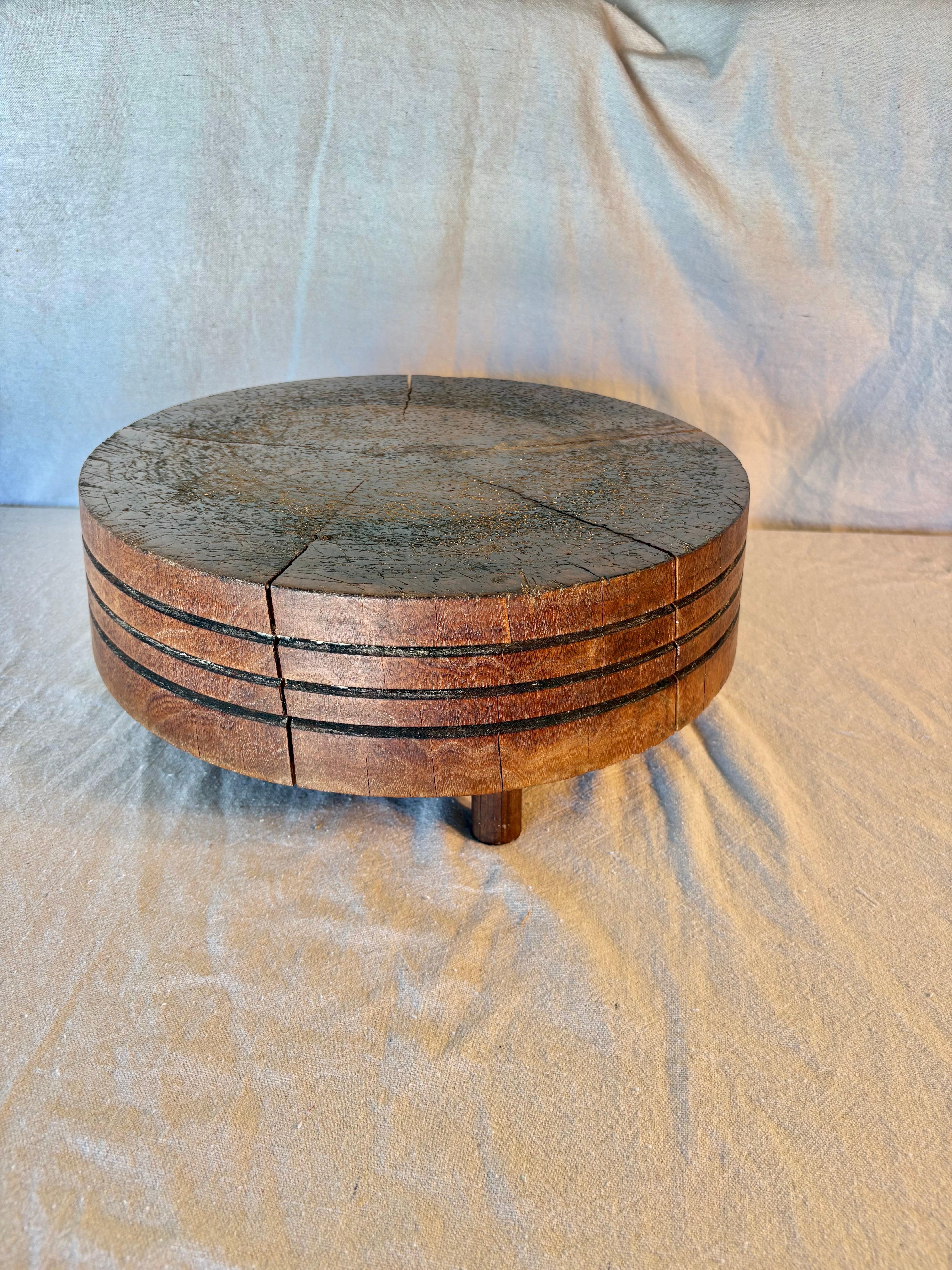 Dieser seltene Tuk-Away Butcher Block aus dem frühen 20. Jahrhundert wurde in den frühen 1900er Jahren aus massivem Holz handgefertigt. Das Stück besteht aus einem runden Butcherblock mit drei handgeschnitzten Ringen an der Seite und steht auf drei