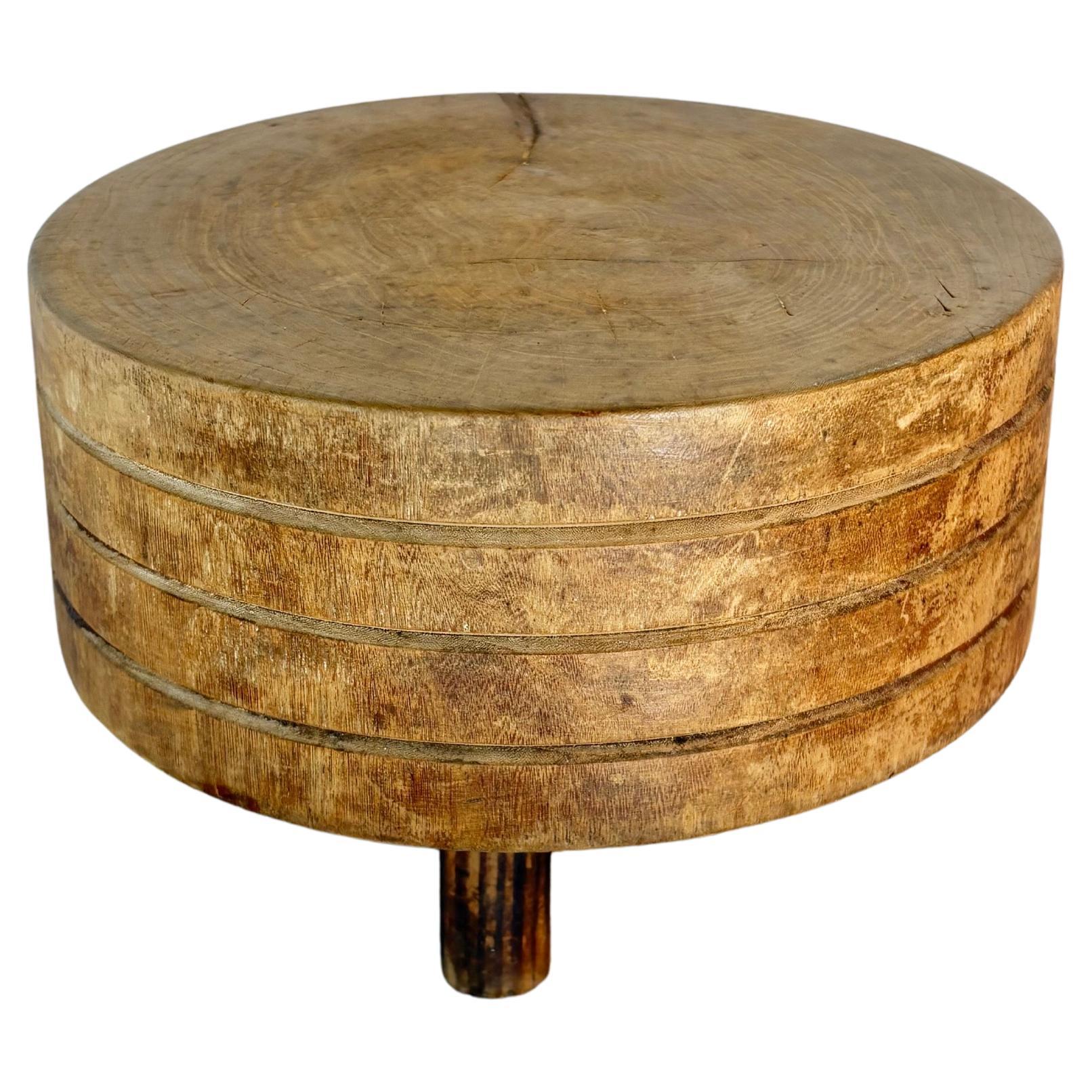 Dieser seltene Tuk-Away Butcher Block aus dem frühen 20. Jahrhundert wurde in den frühen 1900er Jahren aus massivem Holz handgefertigt. Das Stück besteht aus einem runden Butcherblock mit drei handgeschnitzten Ringen an der Seite und steht auf drei