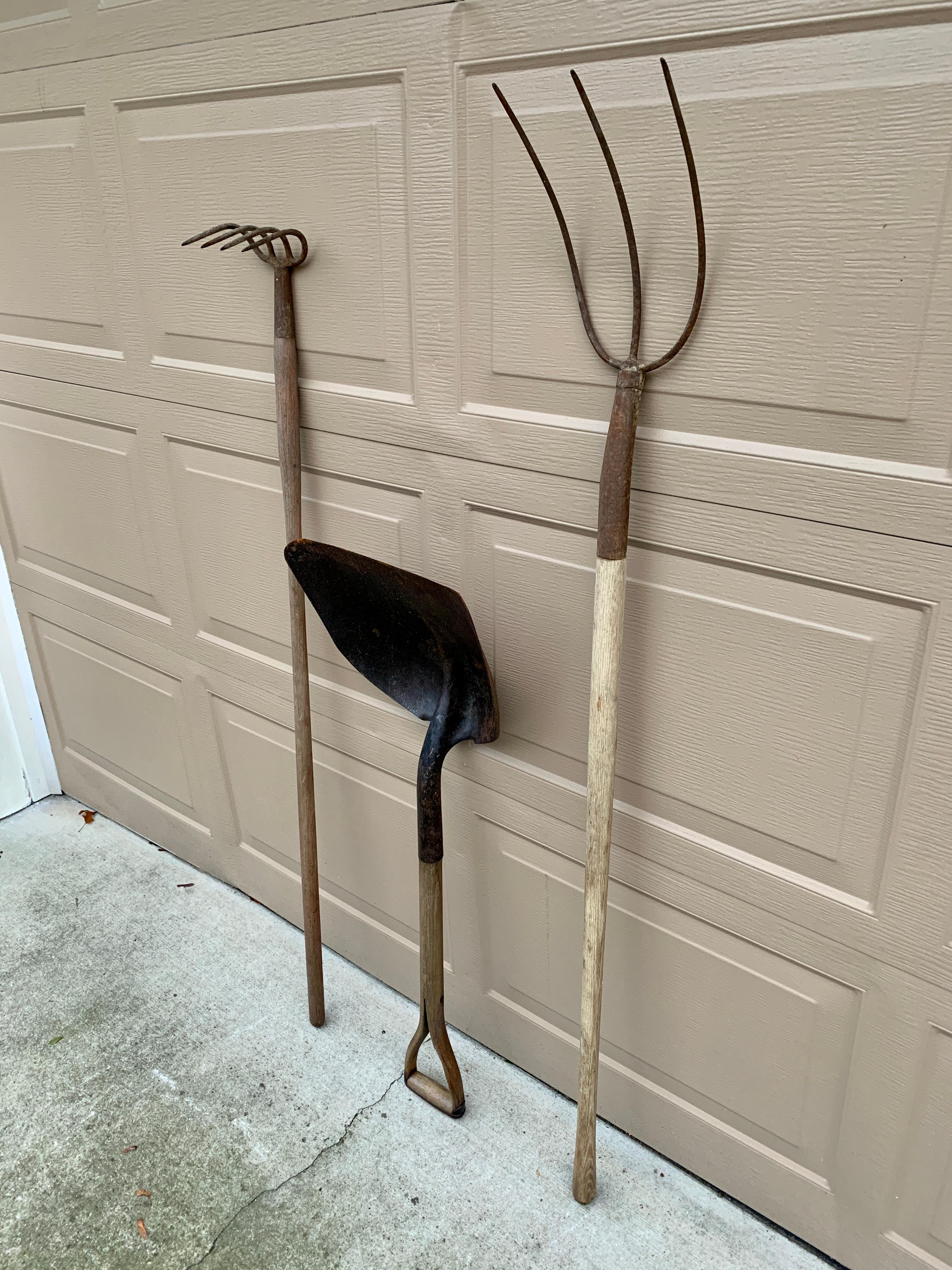 A beautiful set of three antique wooden & iron hand made garden tools. These would be ideal for an installation on a large wall on custom wall mounts. They would add charm and character to a country house or modern farmhouse. 

USA, Circa early 20th