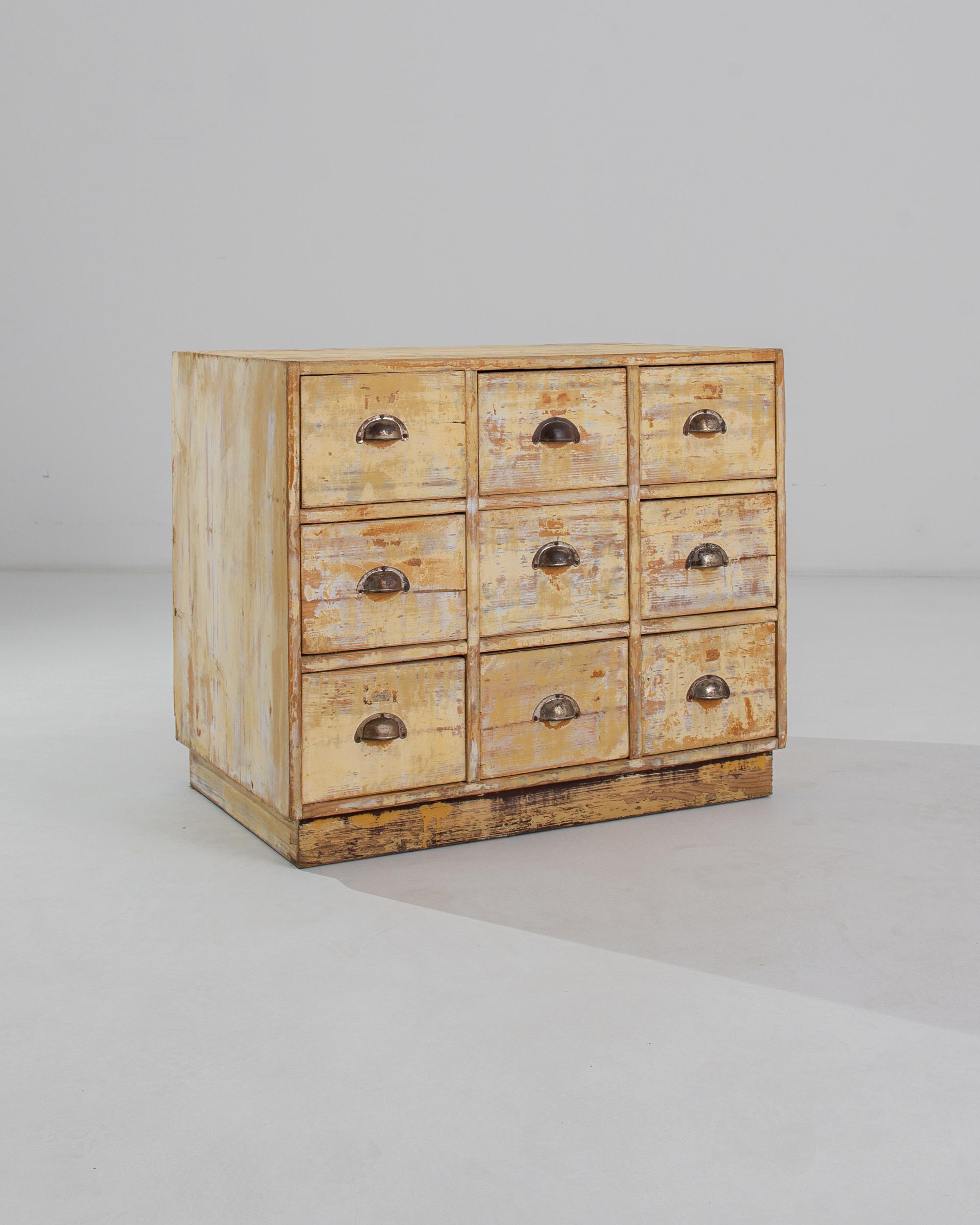 An attractive patina gives this utilitarian nine-drawer chest a sweet, nostalgic character. Made in Central Europe in the early 20th Century, the deep square shape of the drawers indicates that this piece was once likely used for filing papers in a