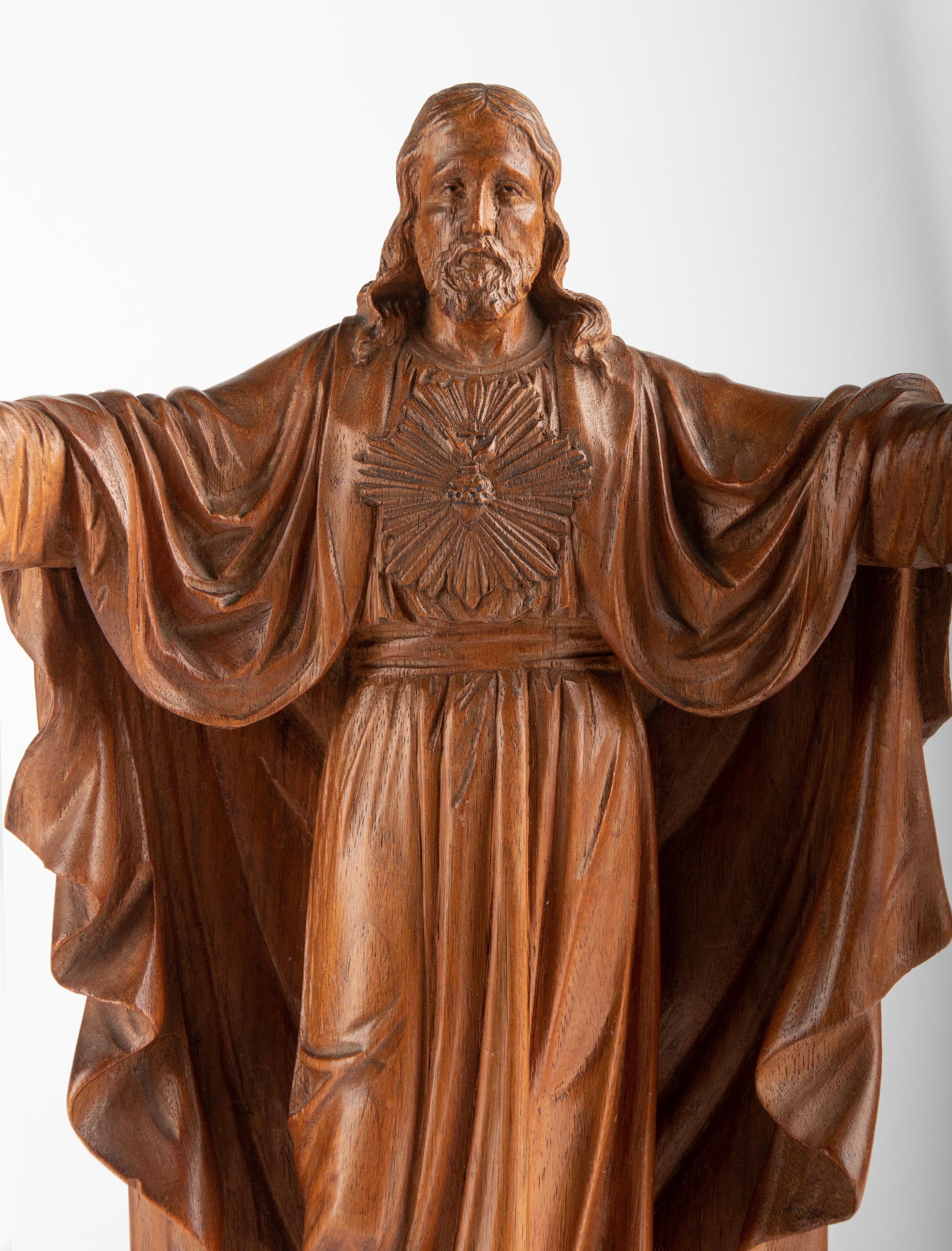 Beautiful wooden sculpture of Jesus Christ with the Sacred Heart and open arms. The statue is made of a soft wood, probably basswood. The carving is very refined, with great attention to detail. This type of woodcarving is a craft that hardly occurs