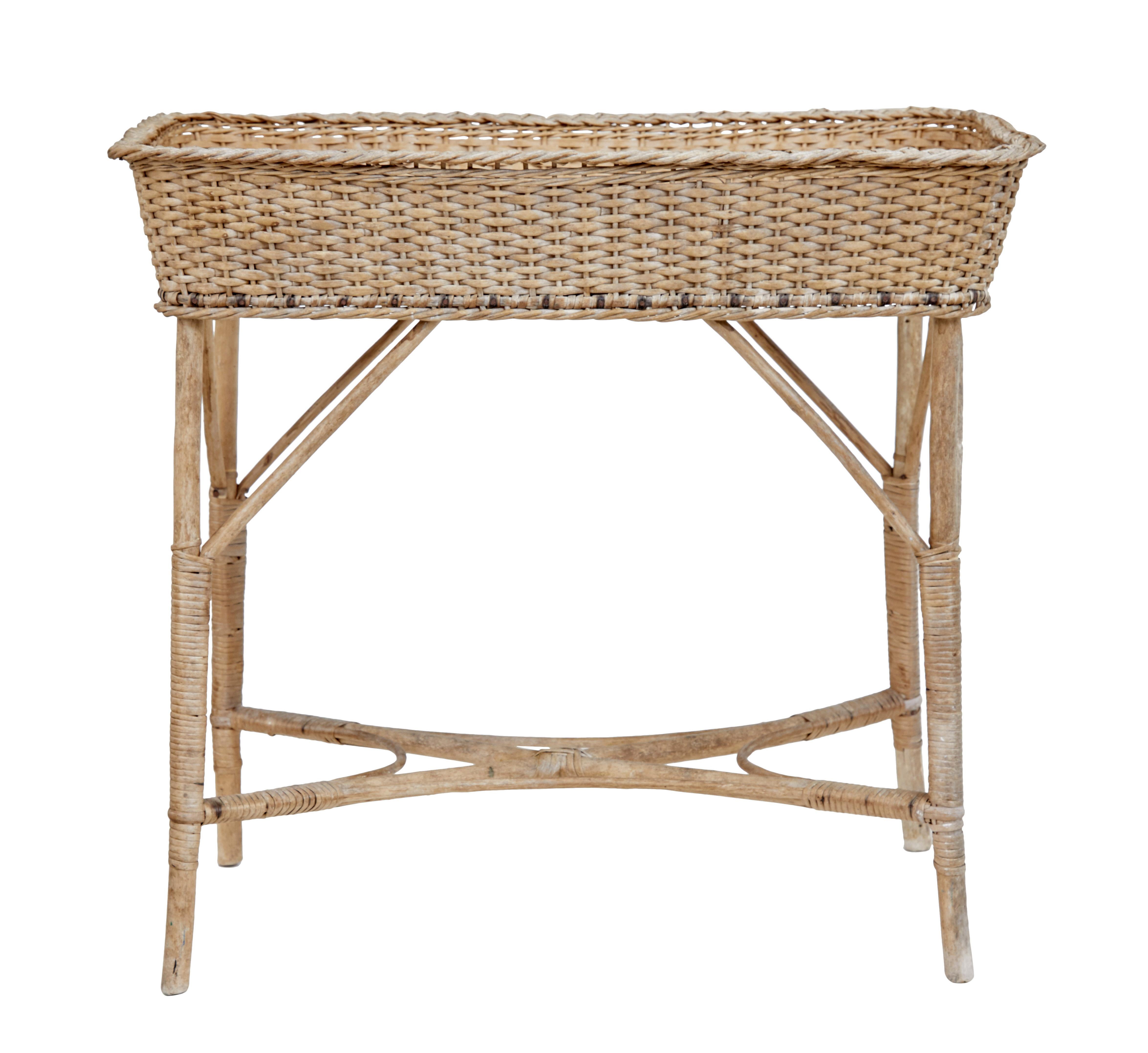 Early 20th century woven cane work jardinière stand, circa 1920.

Traditionally made Swedish jardinière wicker basket on canework base. Ideal for use in the garden room.

Minor surface fading. Good condition for materials and age.